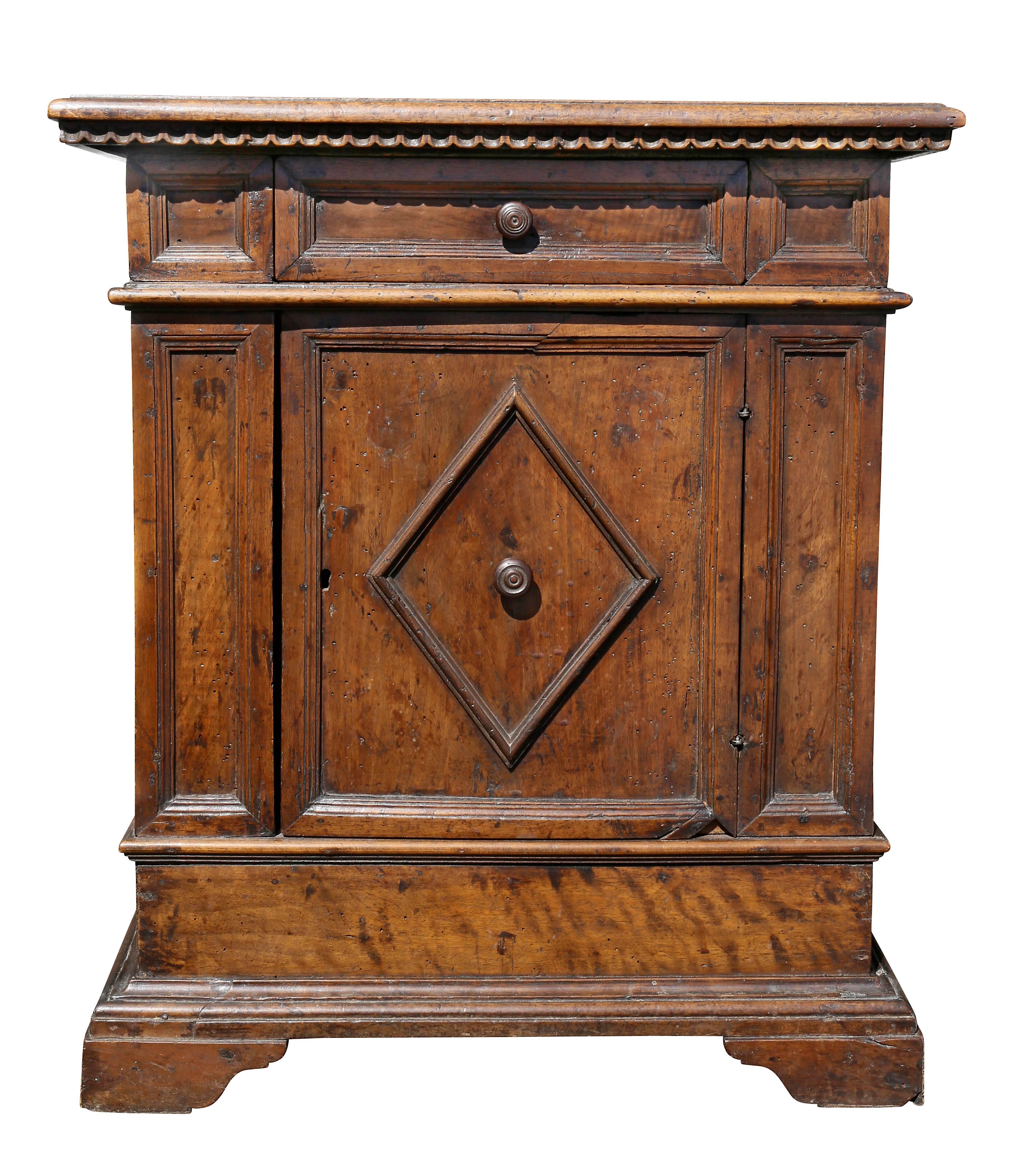 With rectangular top over a single drawer and door with diamond form panel, raised on bracket feet.