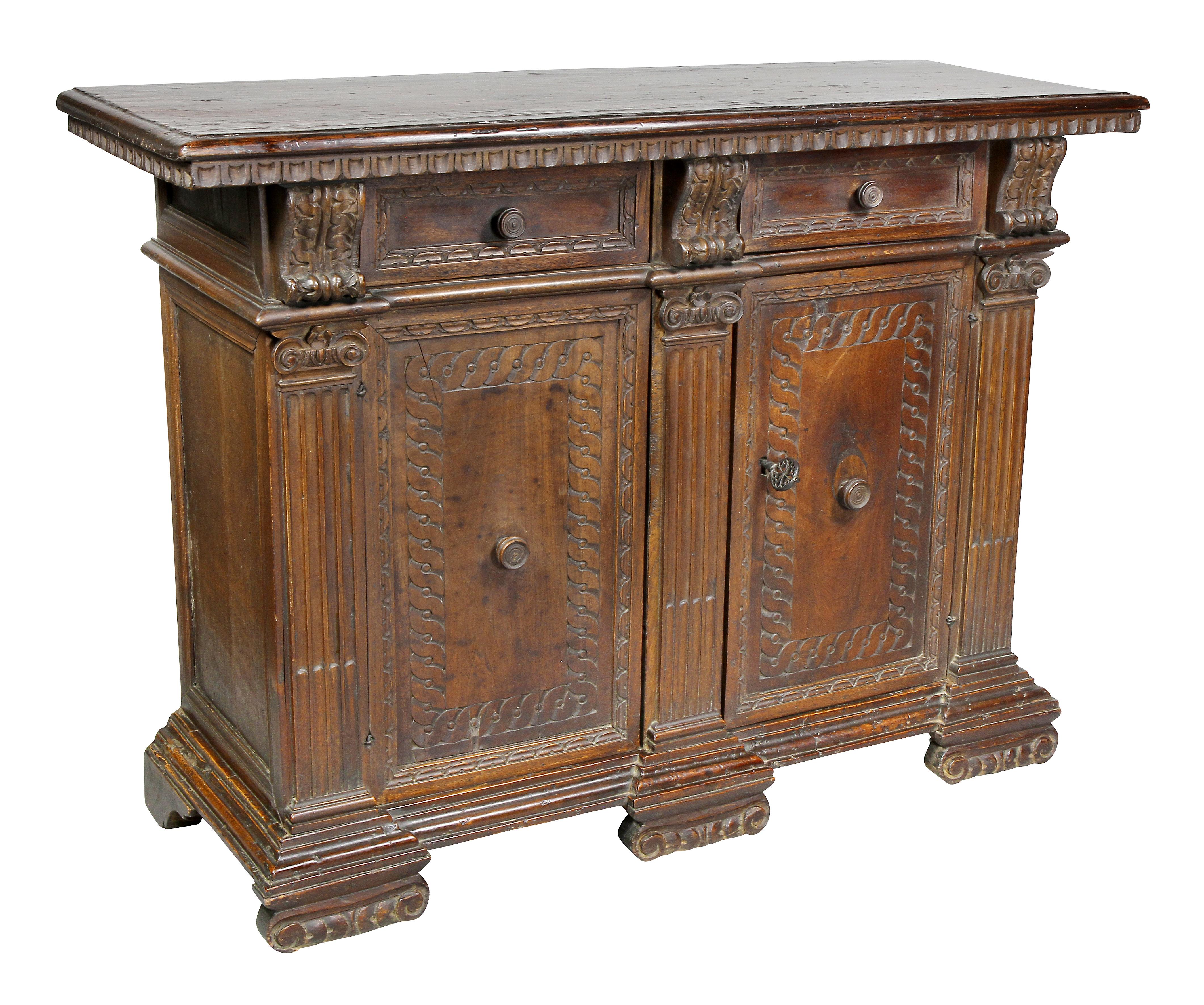 Rectangular top over two drawers flanked by corbels over a pair of doors flanked by columns, carved scrolled feet.