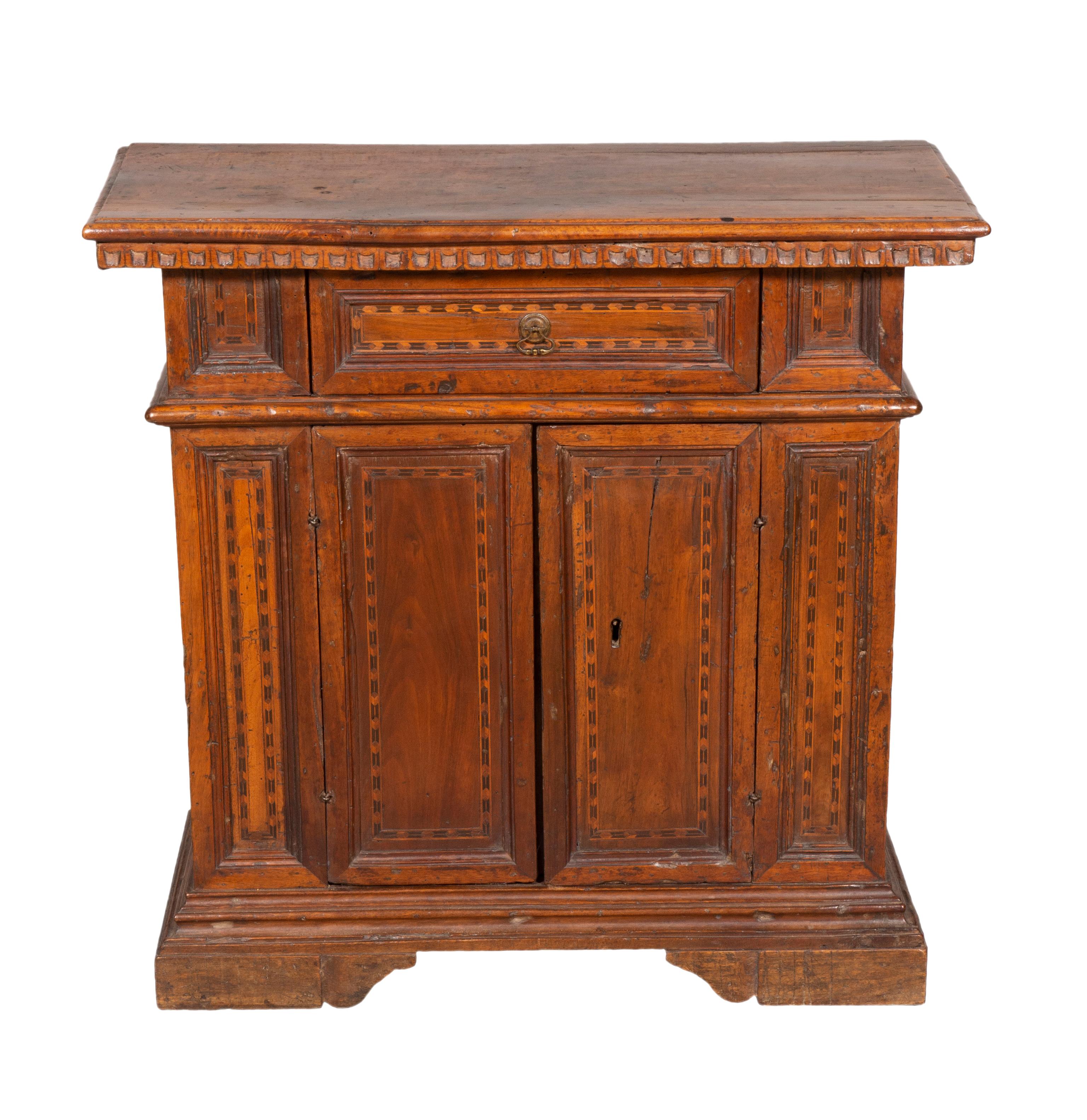 With a rectangular top over a drawer and pair of cabinet doors, bracket base. With inlay around the doors and drawers.