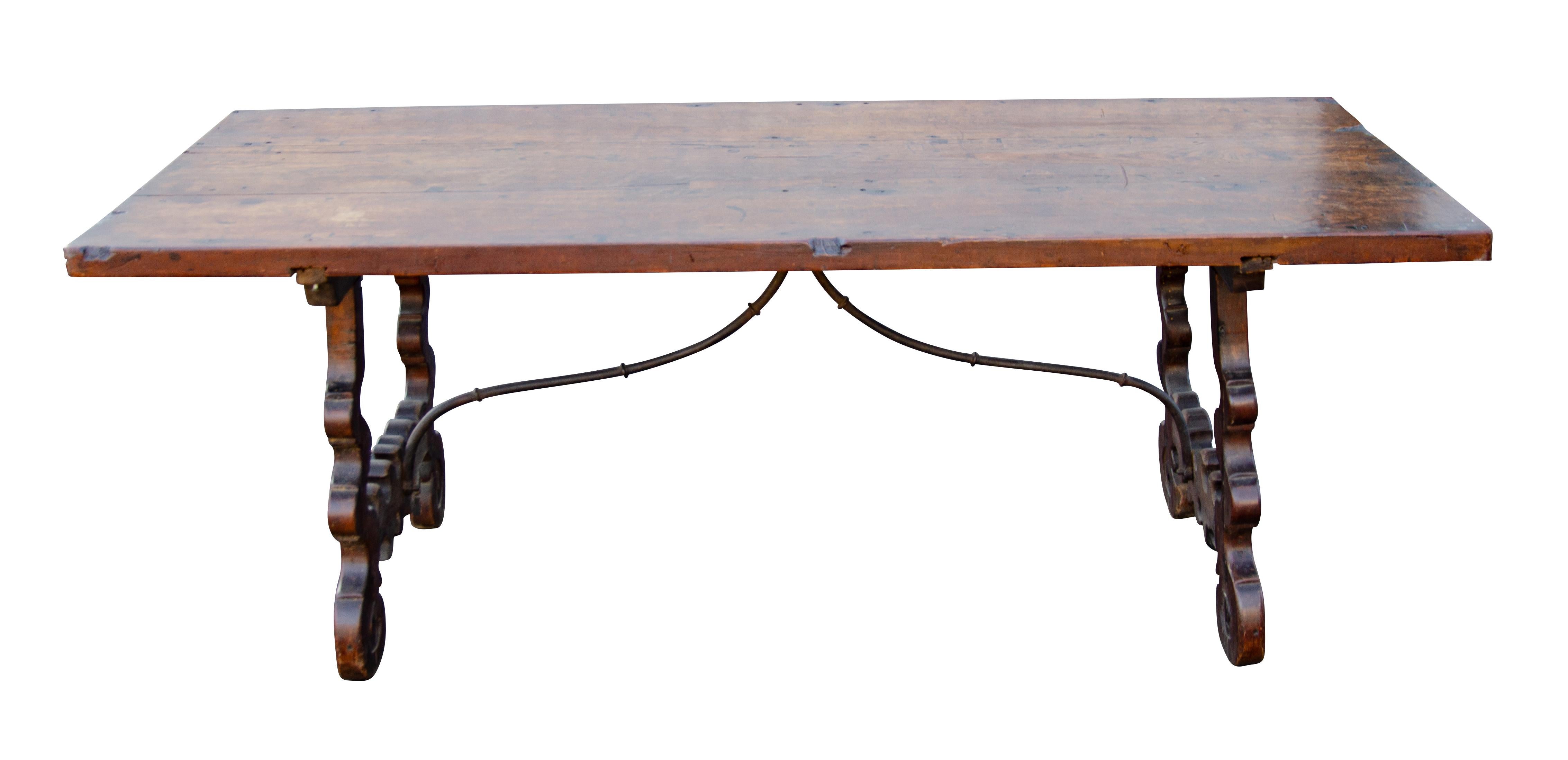 With three board rectangular top raised on scroll cut legs joined by wrought iron stretchers.