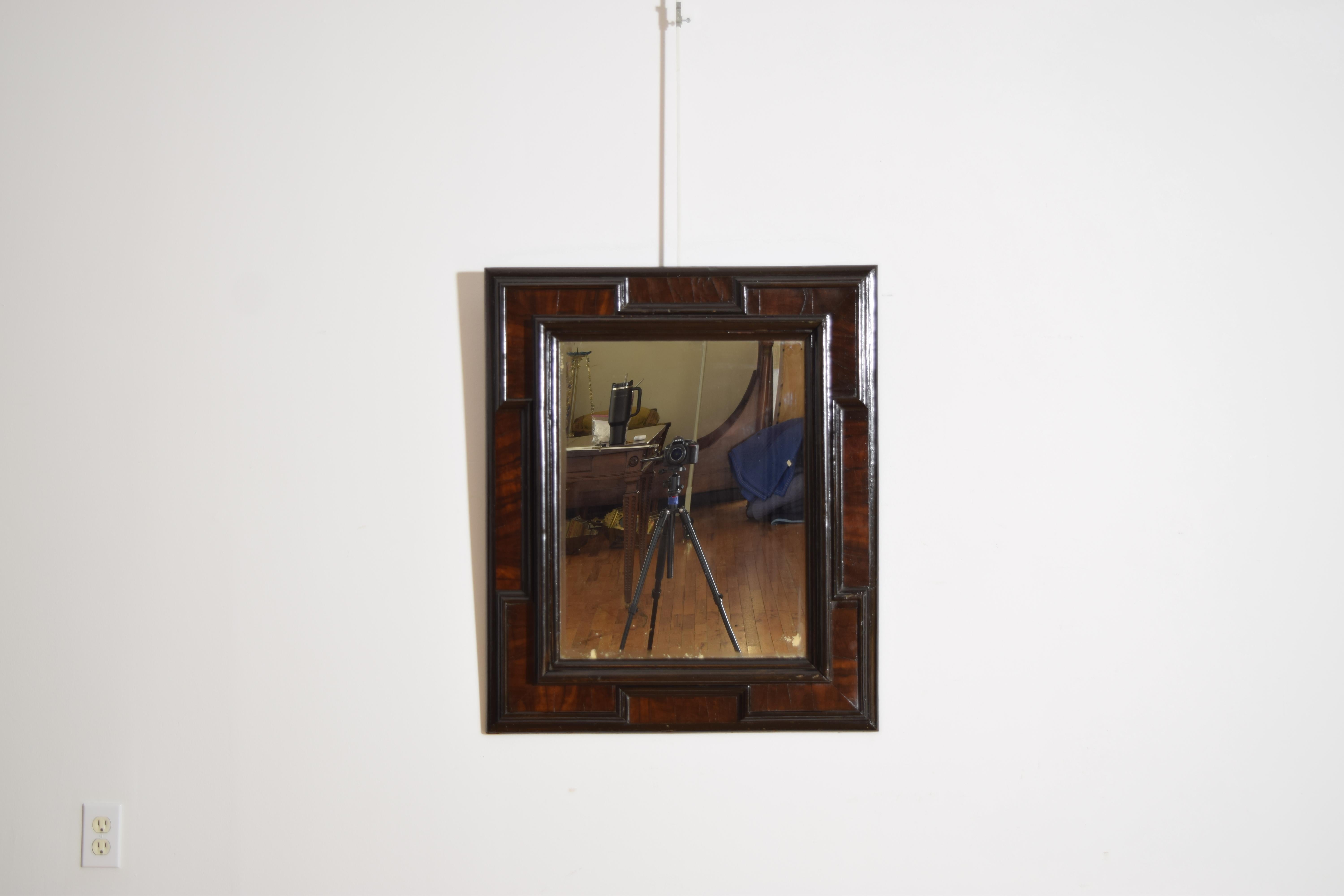 miroir merveilleusement plaqué avec diverses moulures ébonisées et coins en relief, le grain du noyer étant très convoité, conservant une plaque de miroir ancienne.