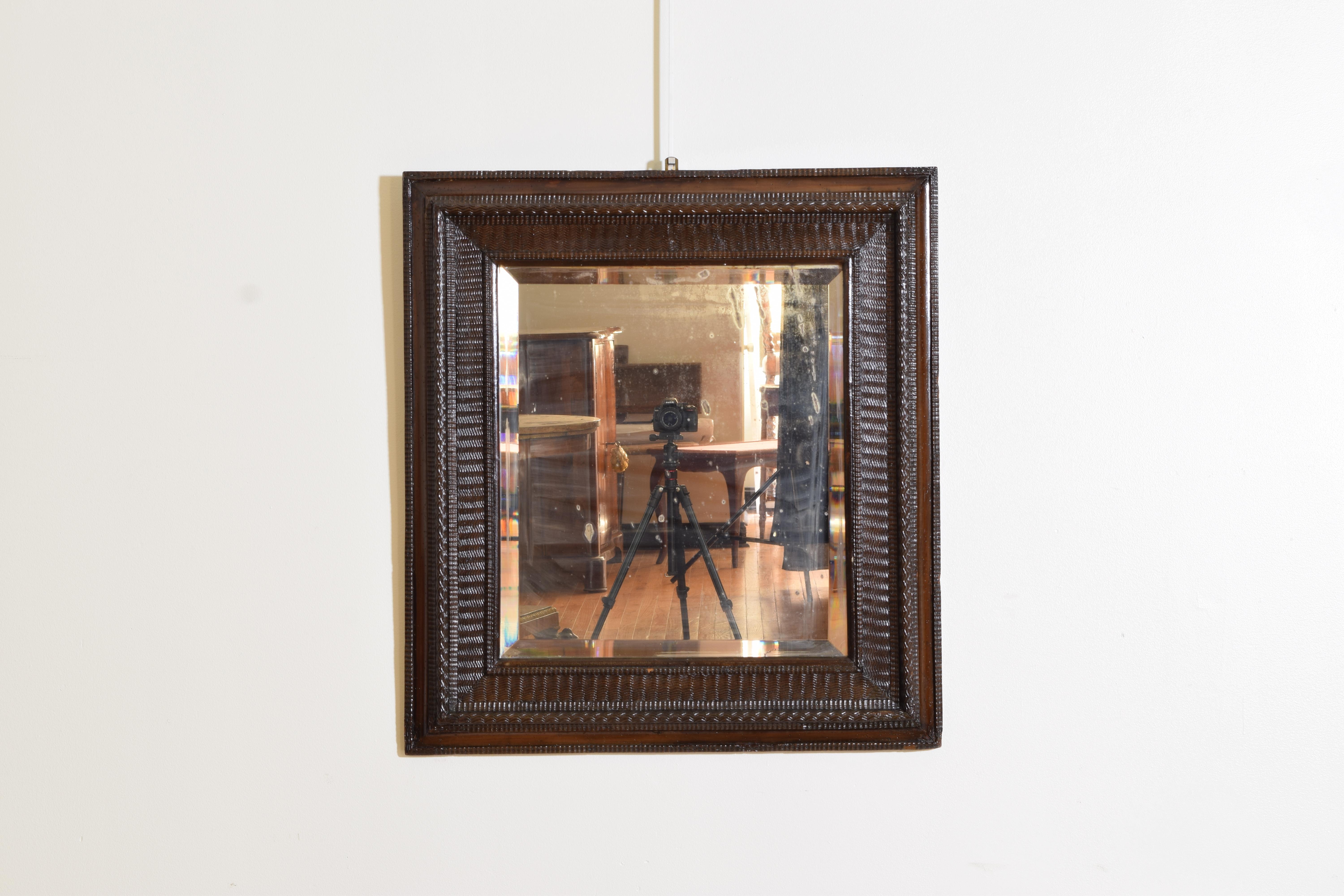 The rectangular frame with guilloche carved moldings, the center molding projecting outward, retaining antique beveled mirrorplate.