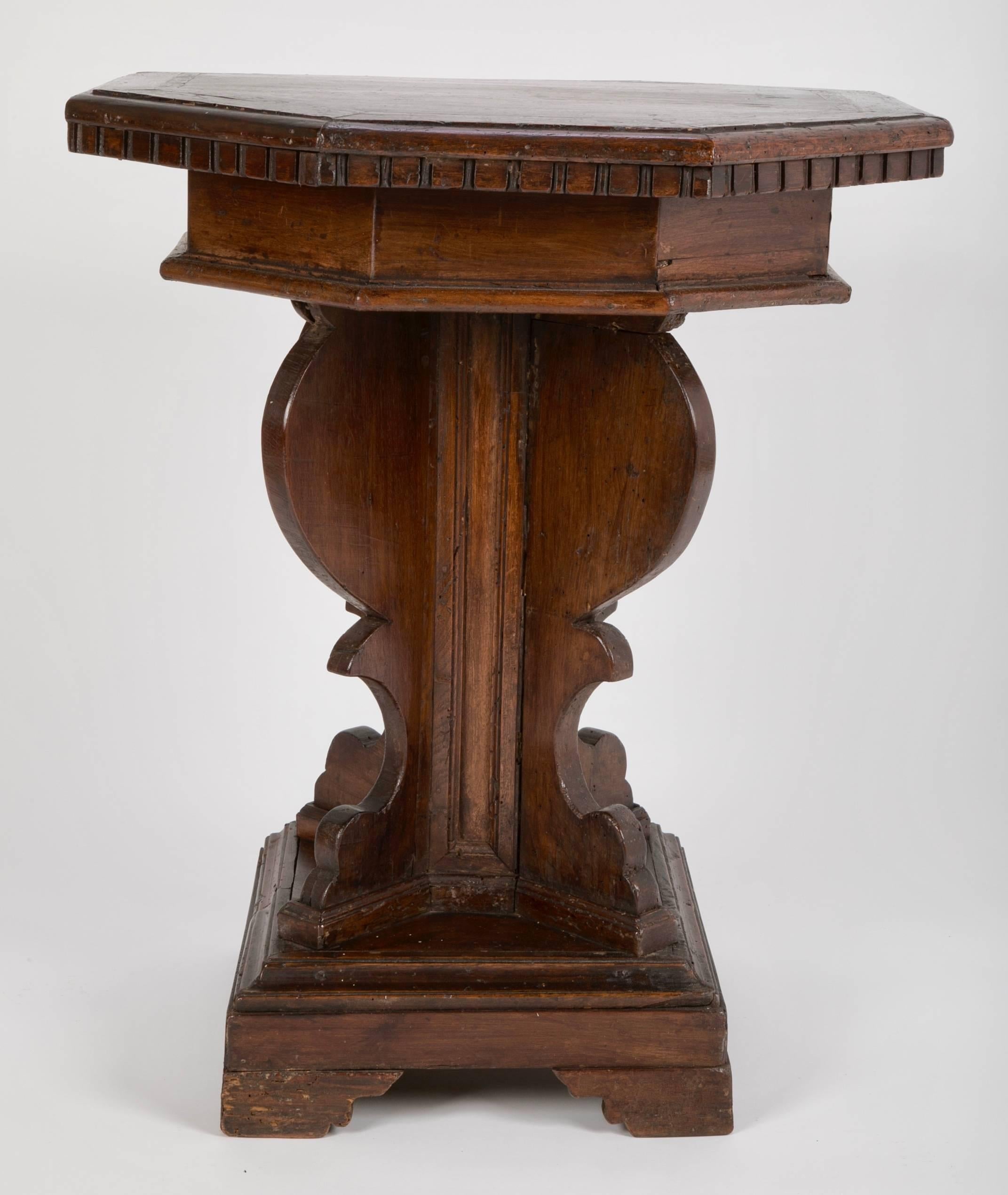 17th century Tuscan walnut octagonal side table. The top with an inlaid band of marquetry and gadrooned molding supported by a vase-form base on a square plinth with four bracket feet. A wonderful example from the Italian Baroque period. The