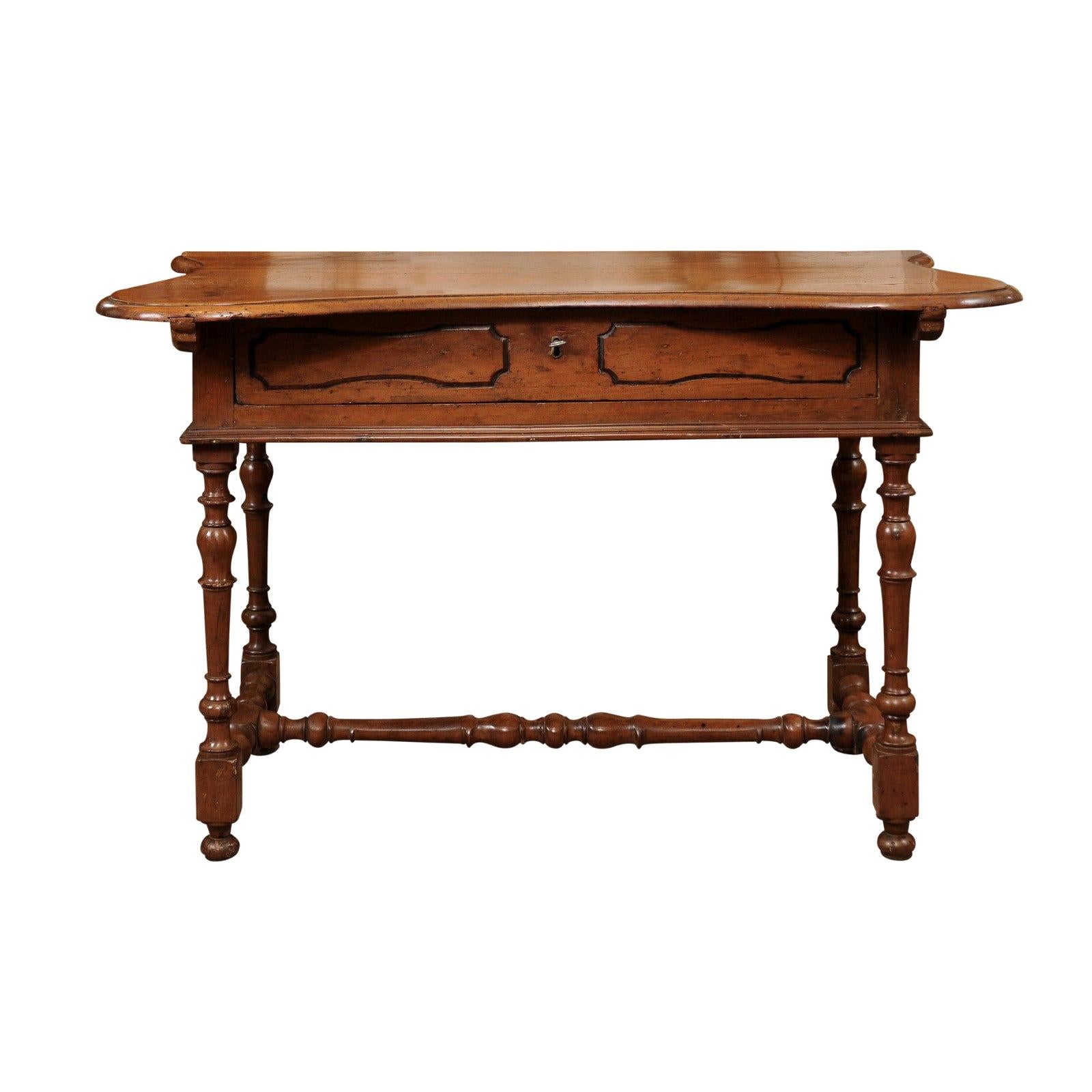 A late 17th century Italian Baroque console table in walnut featuring serpentine top, 1-drawer in frieze, turned legs and stretcher ending in bun feet.

    