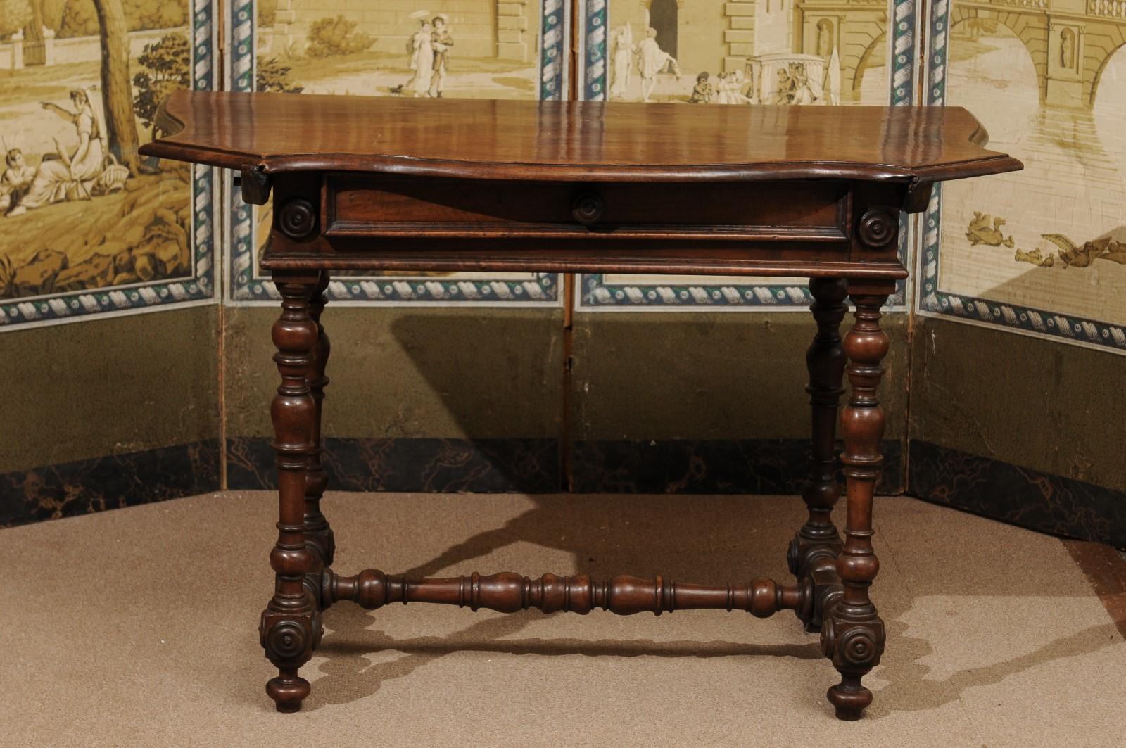 The late 17th century Italian Baroque console table in walnut with serpentine top, drawer below with wood pull and turned legs joined by stretcher ending turned feet. 


  