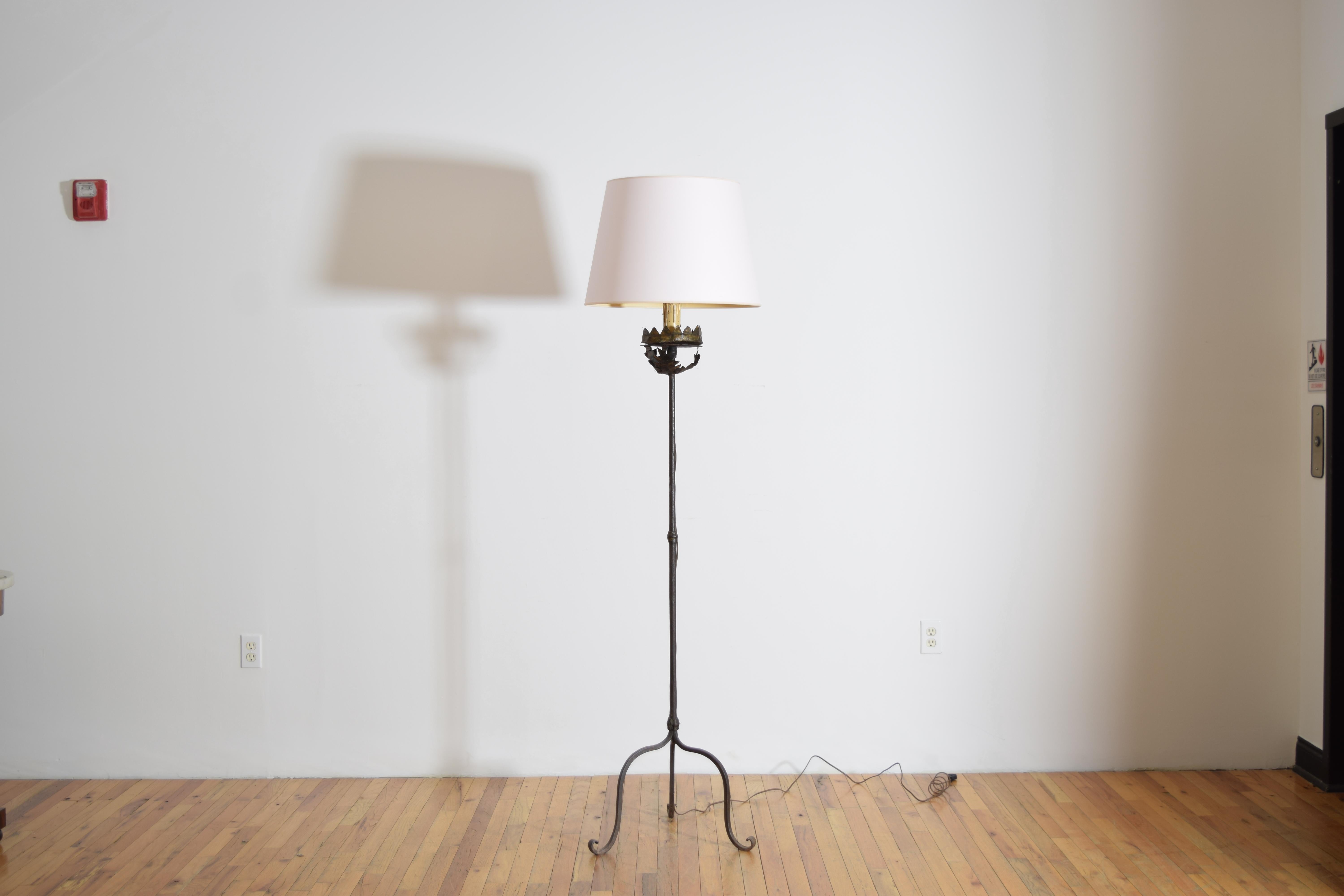 having a gilt metal crown-form drip pan atop a leaf shaped support, all raised on a simple wrought iron shaft above a three leg scolled base