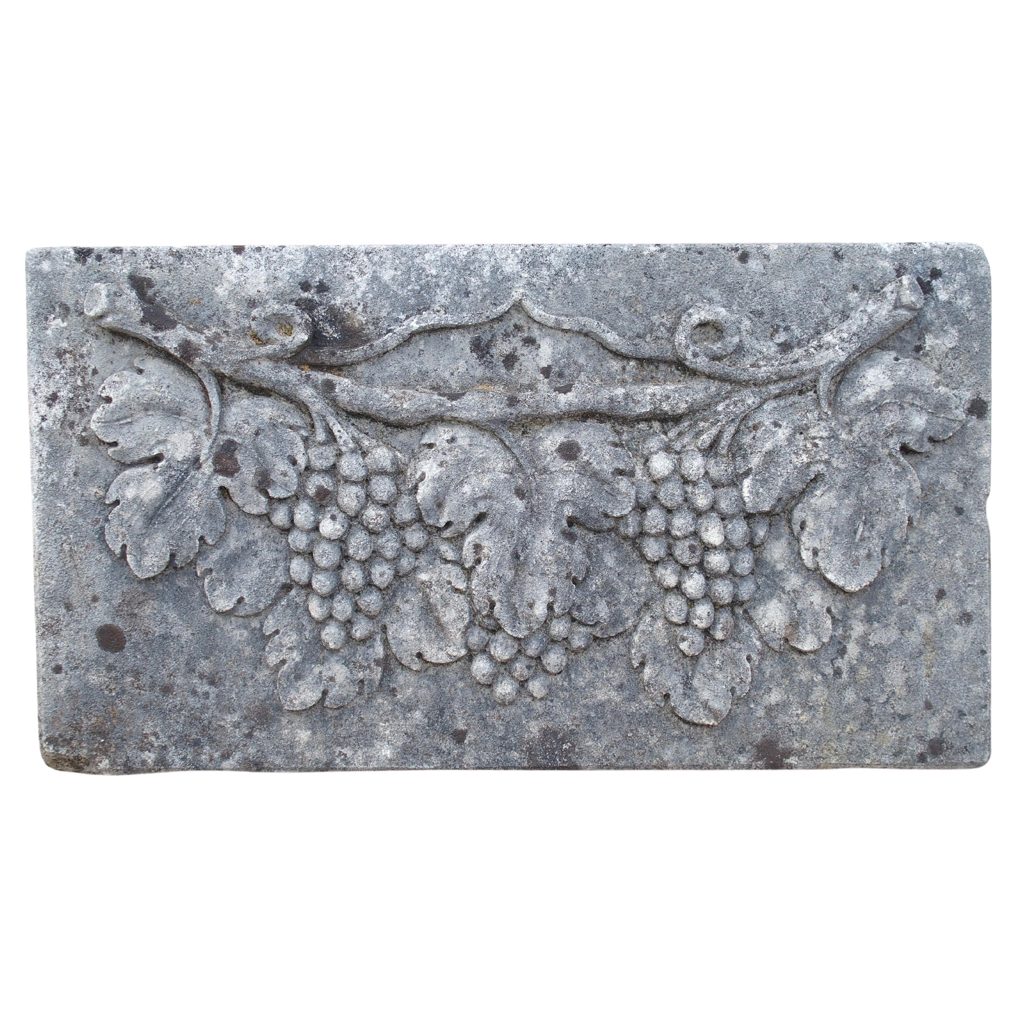 Placa italiana en bajorrelieve de una vid en piedra caliza tallada
