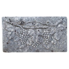 Placa italiana en bajorrelieve de una vid en piedra caliza tallada