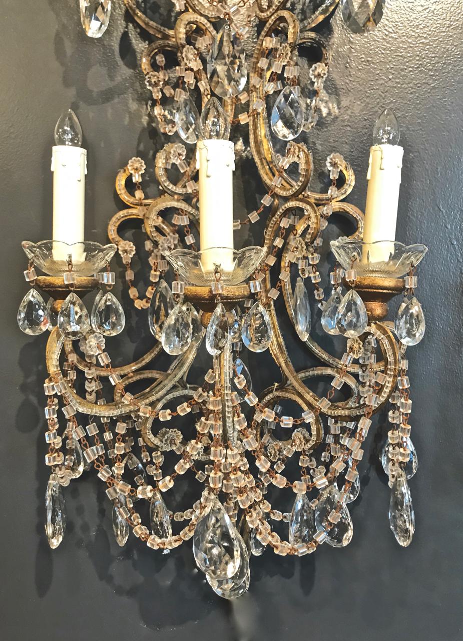 This is a sumptuous pair of large midcentury Italian Beaded Sconces. The sconces measure 48 inches and are detailed with multiple swags of original macaroni beads; beading to the gold leafed brass arms; a profusion of faceted tear drop pendants. The