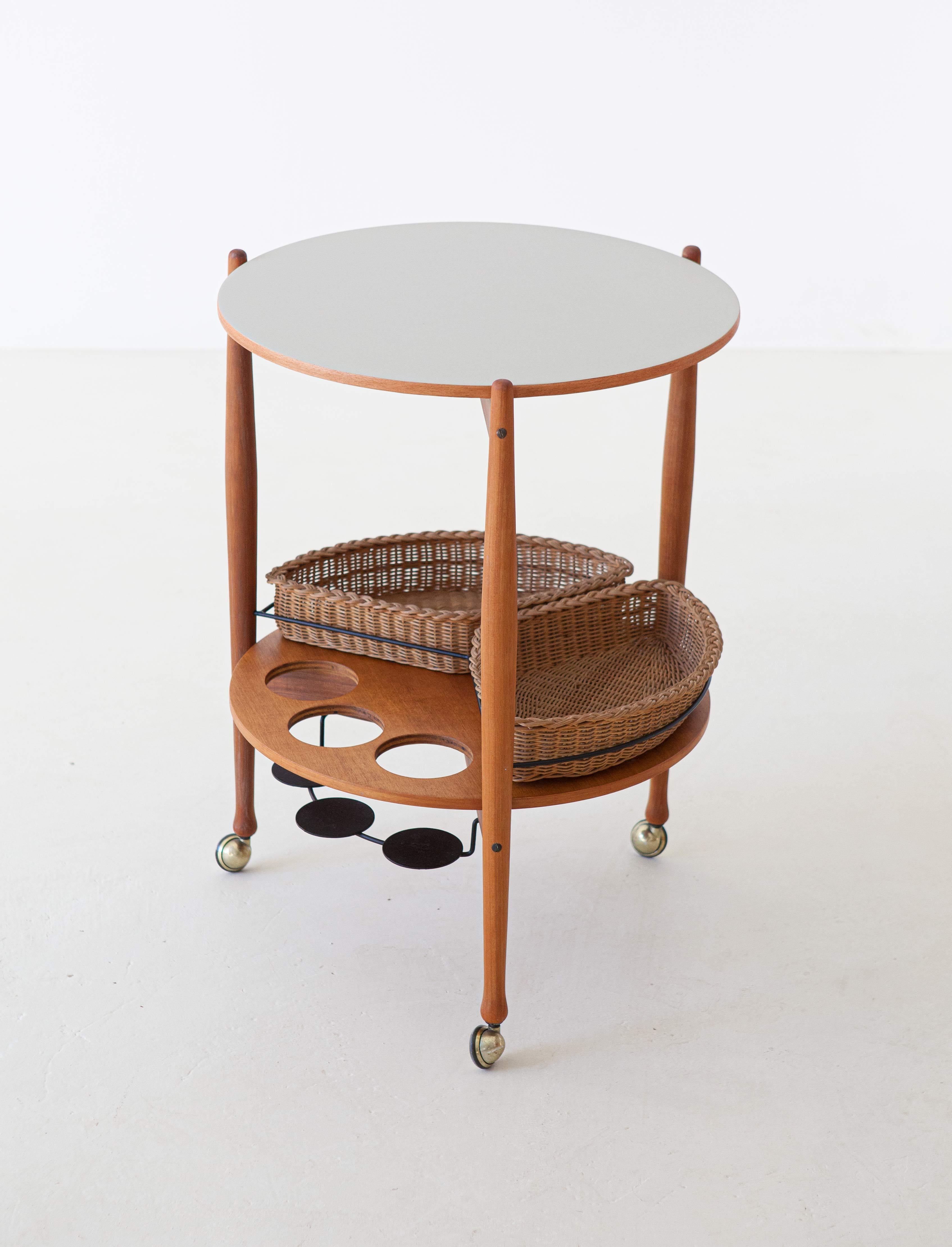 This rare midcentury trolley table was designed and manufactured by Fratelli Reguitti in Italy during the 1950s. 

This bar cart it's made of beechwood with iron and brass details and wicker baskets. 

Completely restored.