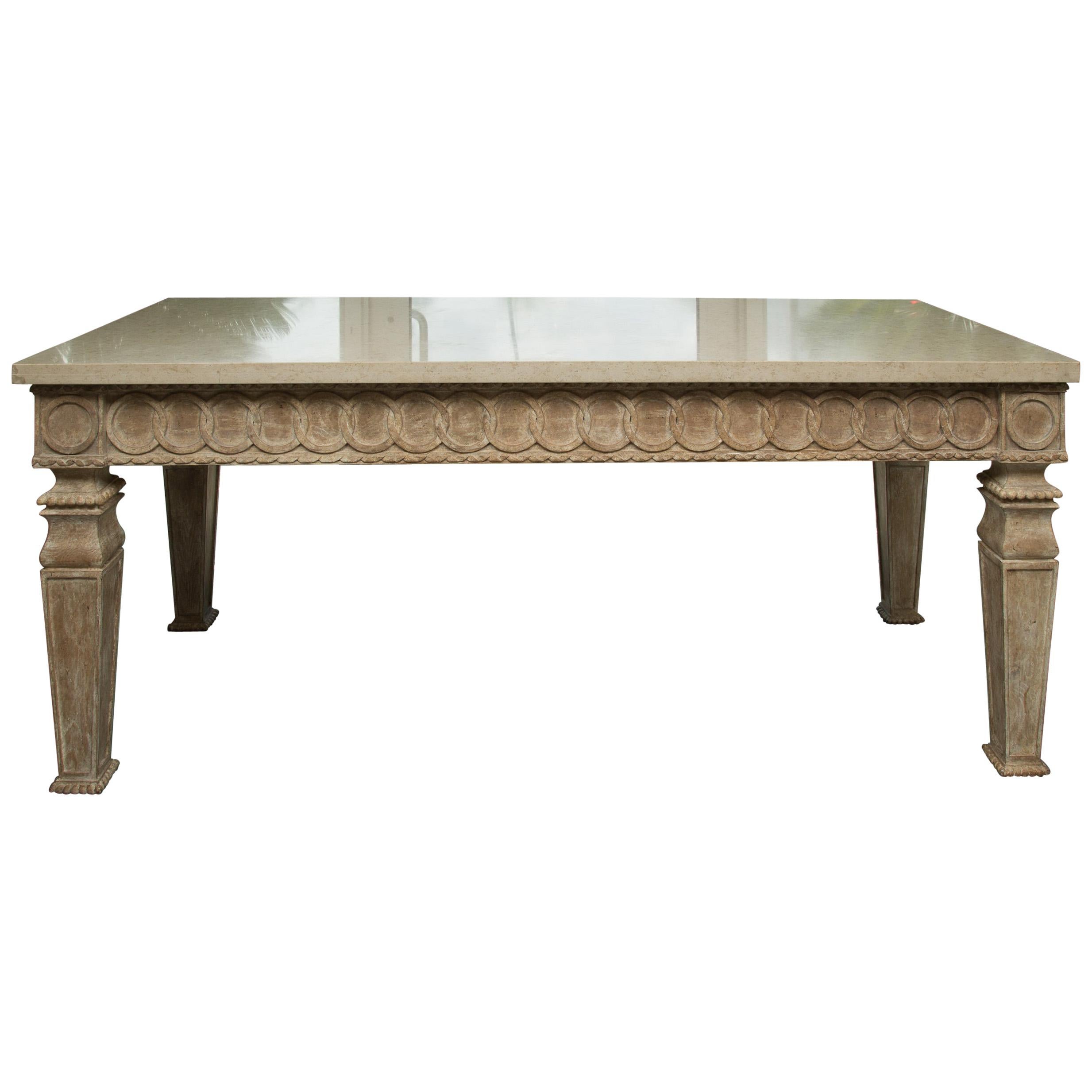 This is an impressive Italian beechwood center table with a cream marble top with straight edge over a prominent frieze carved. The frieze is designed with a series hand of carved interlocking circles and supported by four thick square tapering