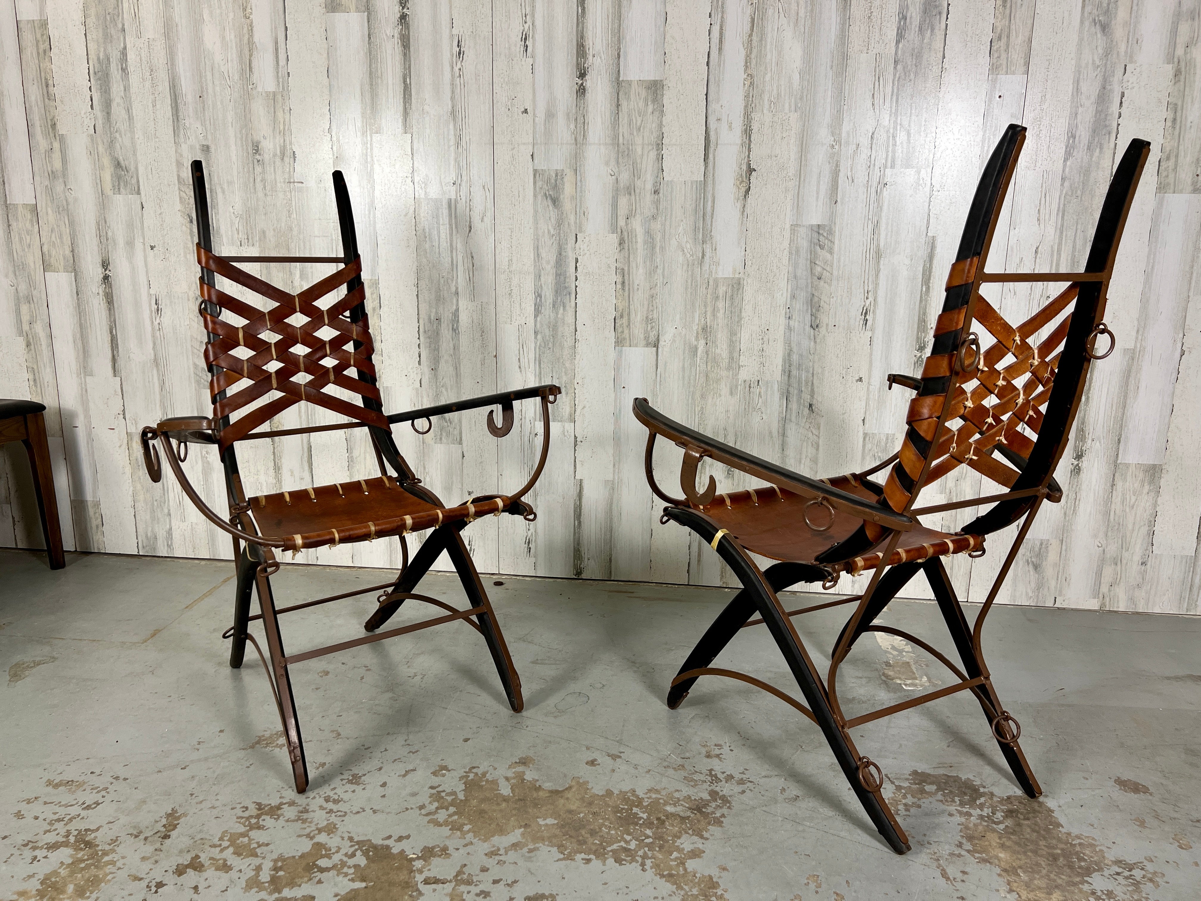 A pair of side chairs by Italian designer Alberto Marconetti, Italian, 1960s. Design .crafted in Iron, oak, leather. Sculpted oak and iron with iron hooks and rings as accents. 
Basket weave design leather back with parchment ties add to the rustic