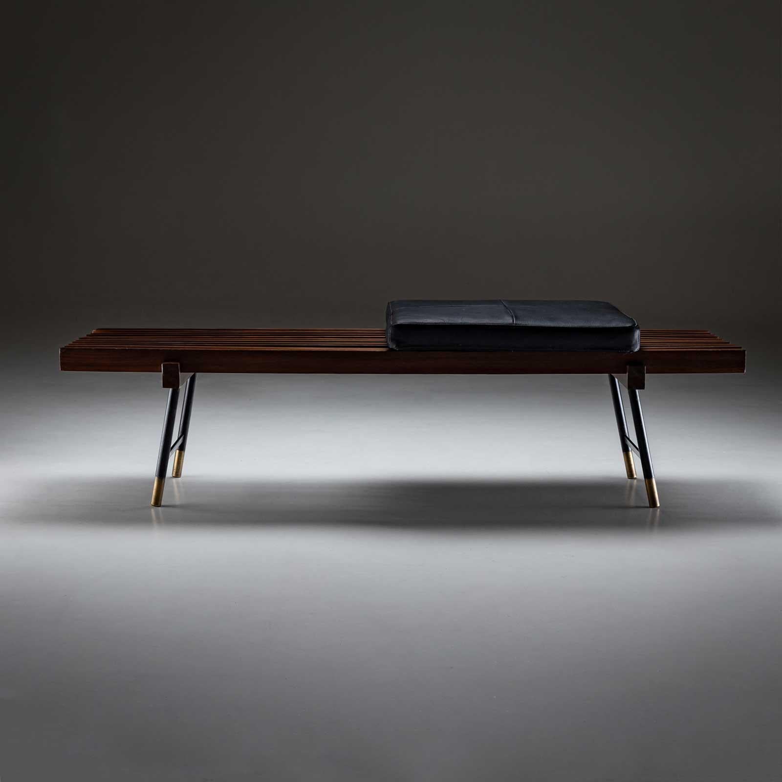 Banc moderne italien sur pieds en métal noir et pieds en laiton. Le siège est constitué de lattes et est équipé d'un coussin carré noir recouvert de cuir.