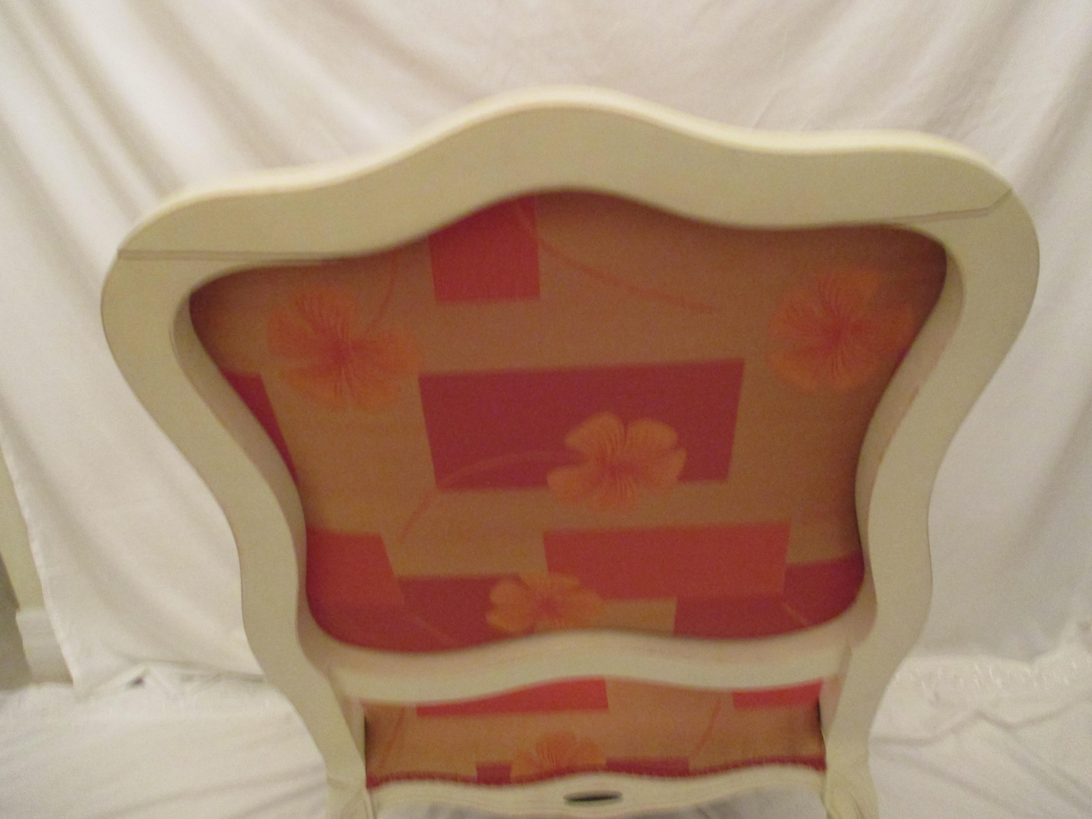 Bergere chair made in Italy with original orange floral upholstery in good condition. Chair has crack in top of the back of the chair.
