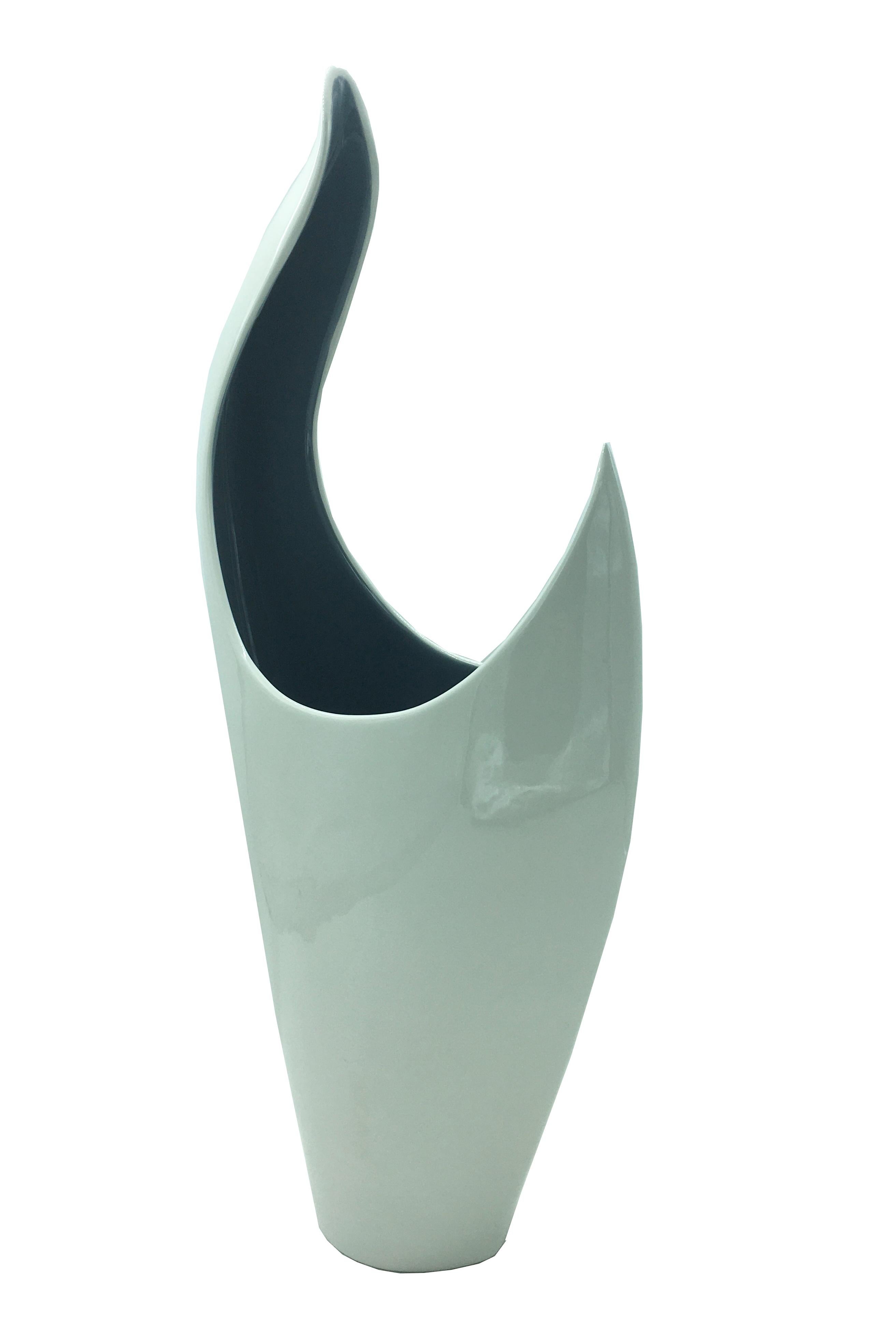 Elegant indoor vase made of fine white ceramic with gray interior.
Italian design with simple and sinuous shapes.