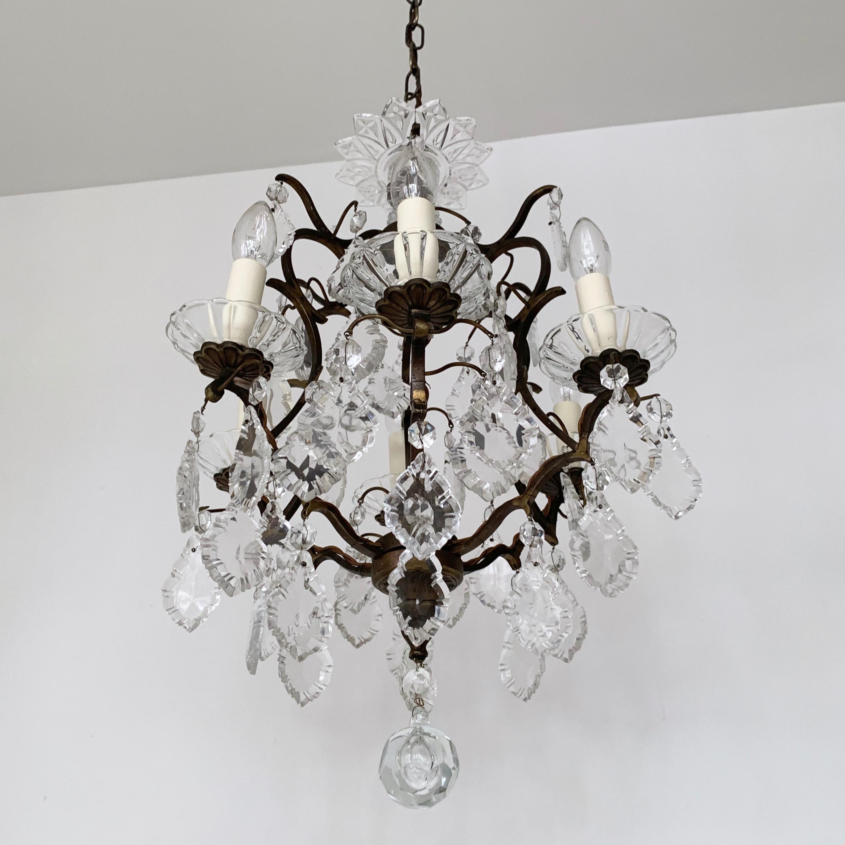 This birdcage chandelier originates from early 1900s Italy. Dressed glass flat leaf drops each finished with a crystal button with elegant proportions it would make an excellent centre piece. The brass chandelier frame has a dark naturally oxidised