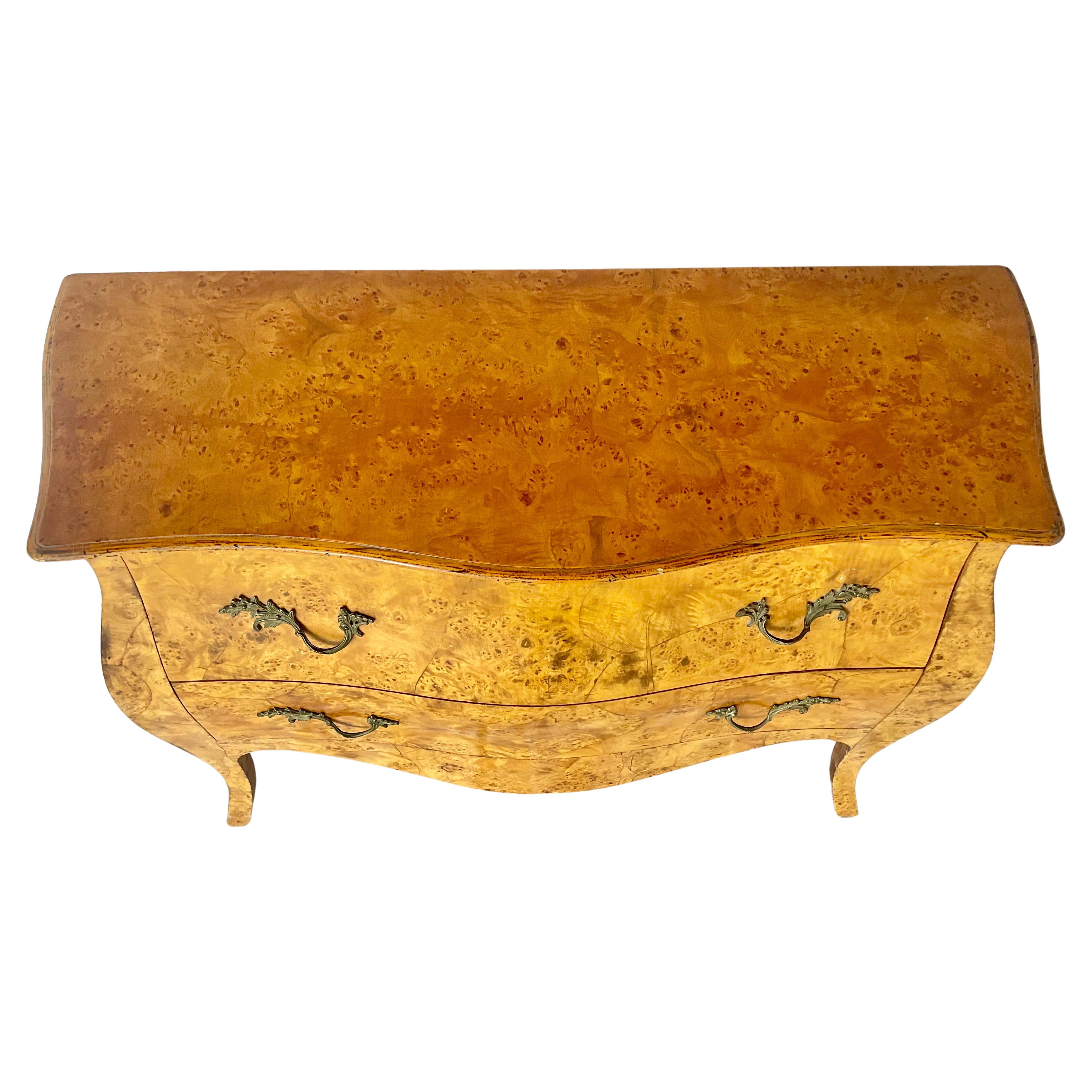 Cassapanca italiana in acero a occhio di bue. La cassettiera presenta una classica forma a serpentina Bombe con due cassetti spaziosi, ciascuno dotato di maniglie ornate in ottone fuso in stile Rococò. Poggiato su gambe cabriole, il pezzo emana