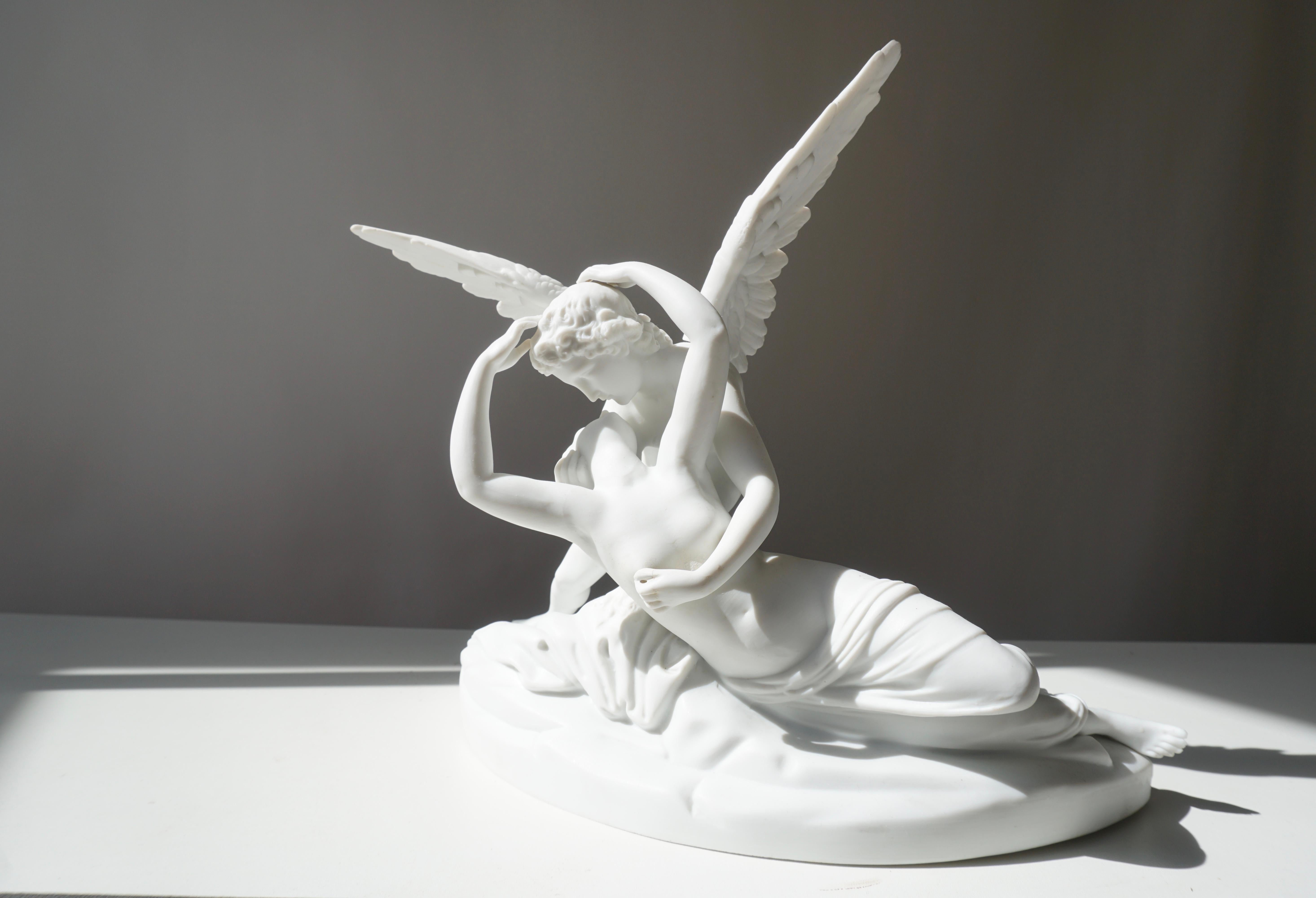 Refined Italian biscuit porcelain sculpture inspired by Canova’s “Psyche Revived by Cupid’s Kiss.” Finely modeled with detachable wings and a soft marble-like finish. Italy, circa 1890–1910.

This exquisite Italian biscuit porcelain sculpture
