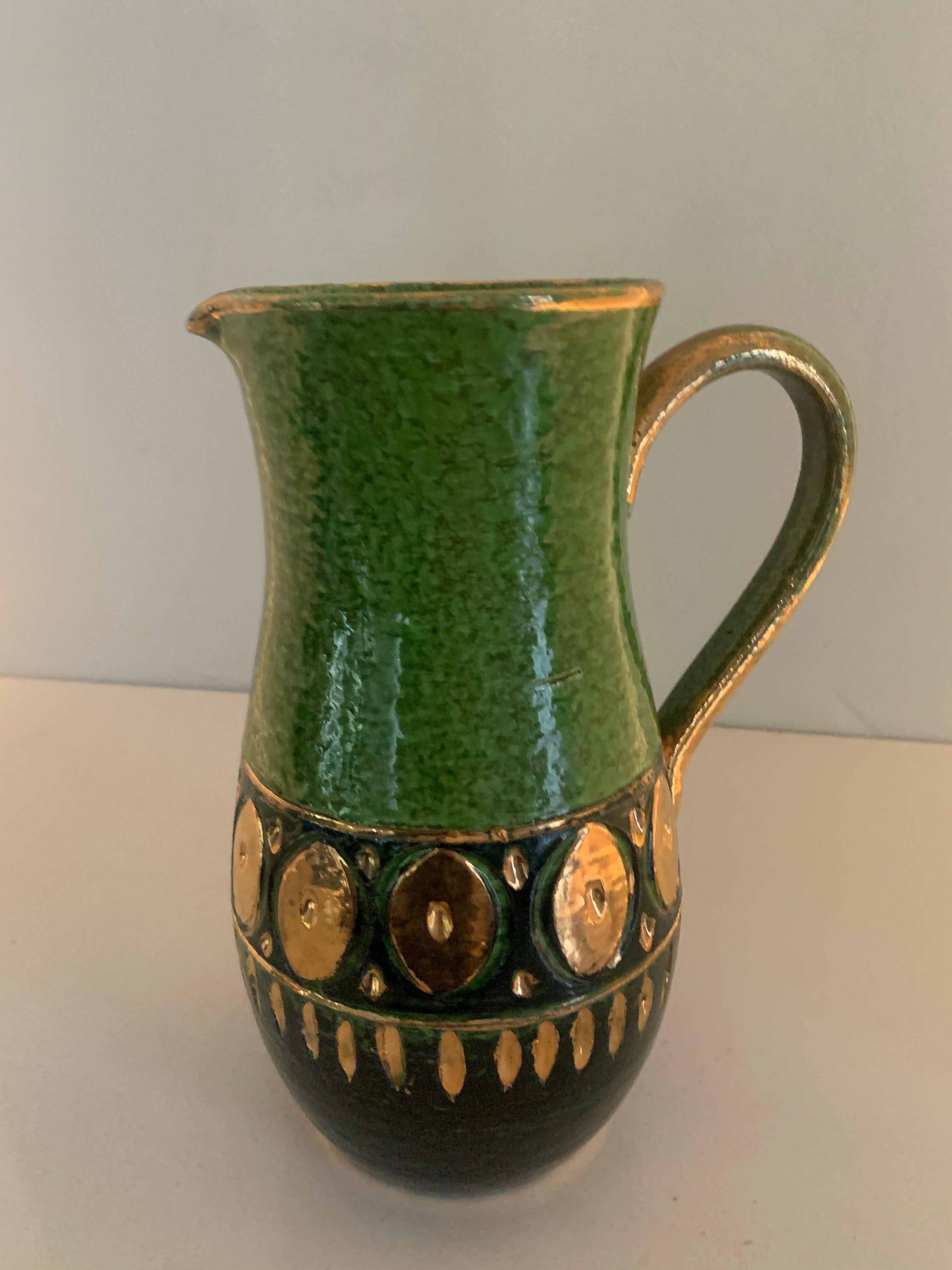 A very nice Bitossi Ceramic Pitcher. One of the best color combinations and designs we have acquired. A compliment to any table or bar setting. The unique green with gold accents is very nice and a Wonderfull mid century representation.