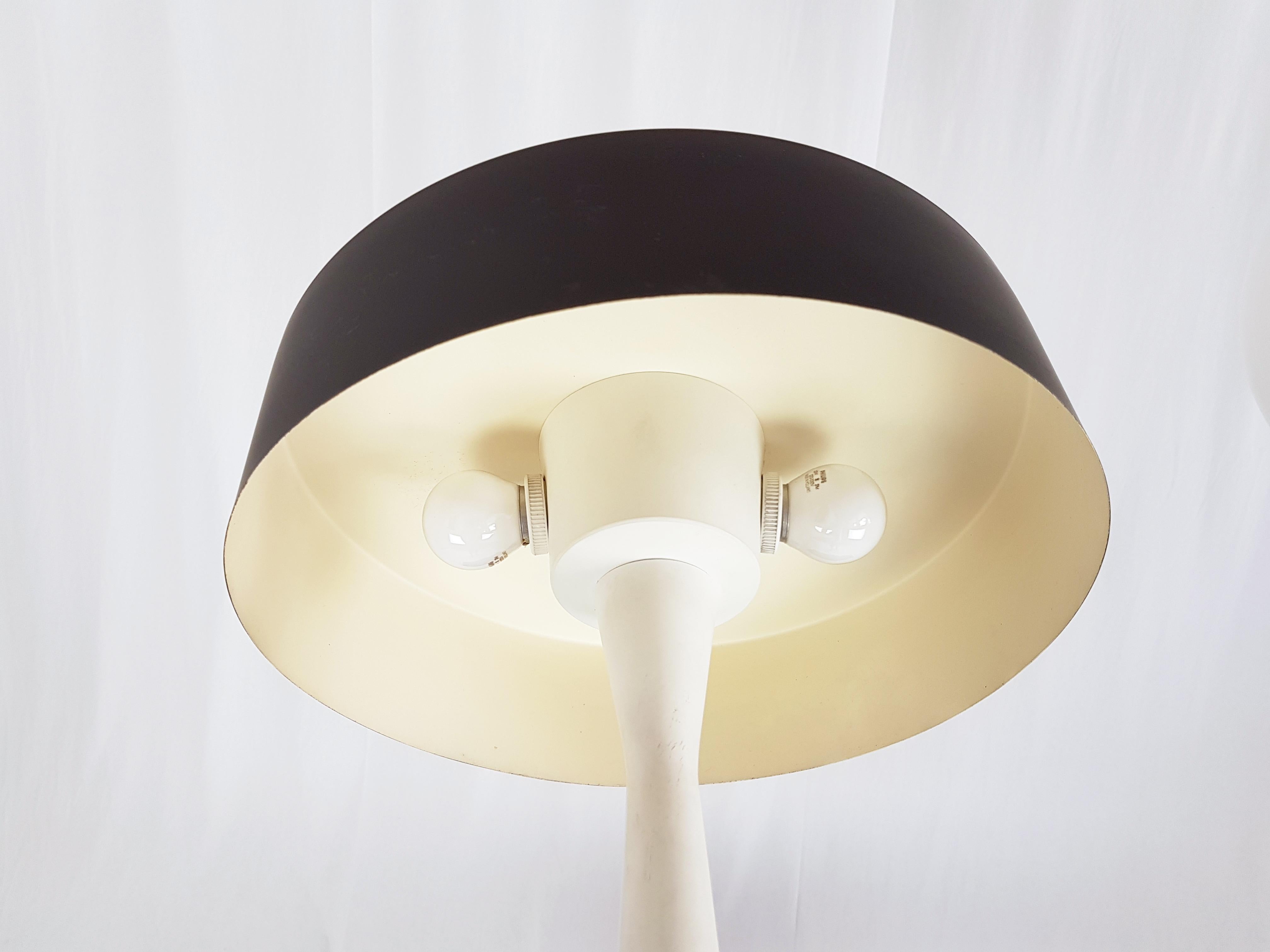 This midcentury table lamp was produced in Italy in the style of Stilnovo. It is made from lacquered aluminum with brass decorations. The lamp features two-light bulb socket (E27) and remains in perfect condition.
