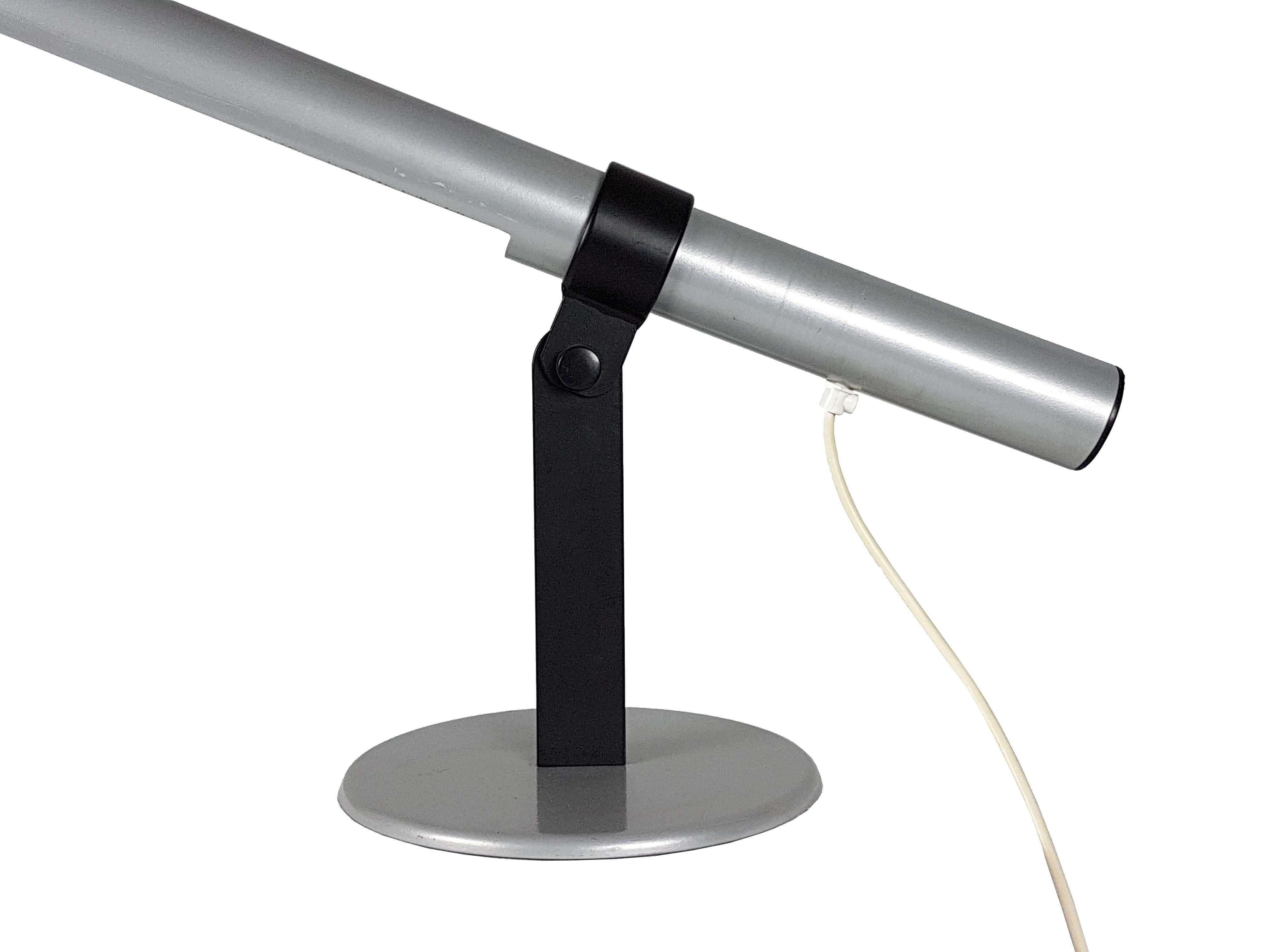 Cette lampe de table postmoderne a été produite en Italie vers 1980. Elle est fabriquée en métal peint en gris argenté et en noir avec un abat-jour néon cylindrique réglable. Son design rappelle les produits postmodernes contemporains de l'école de