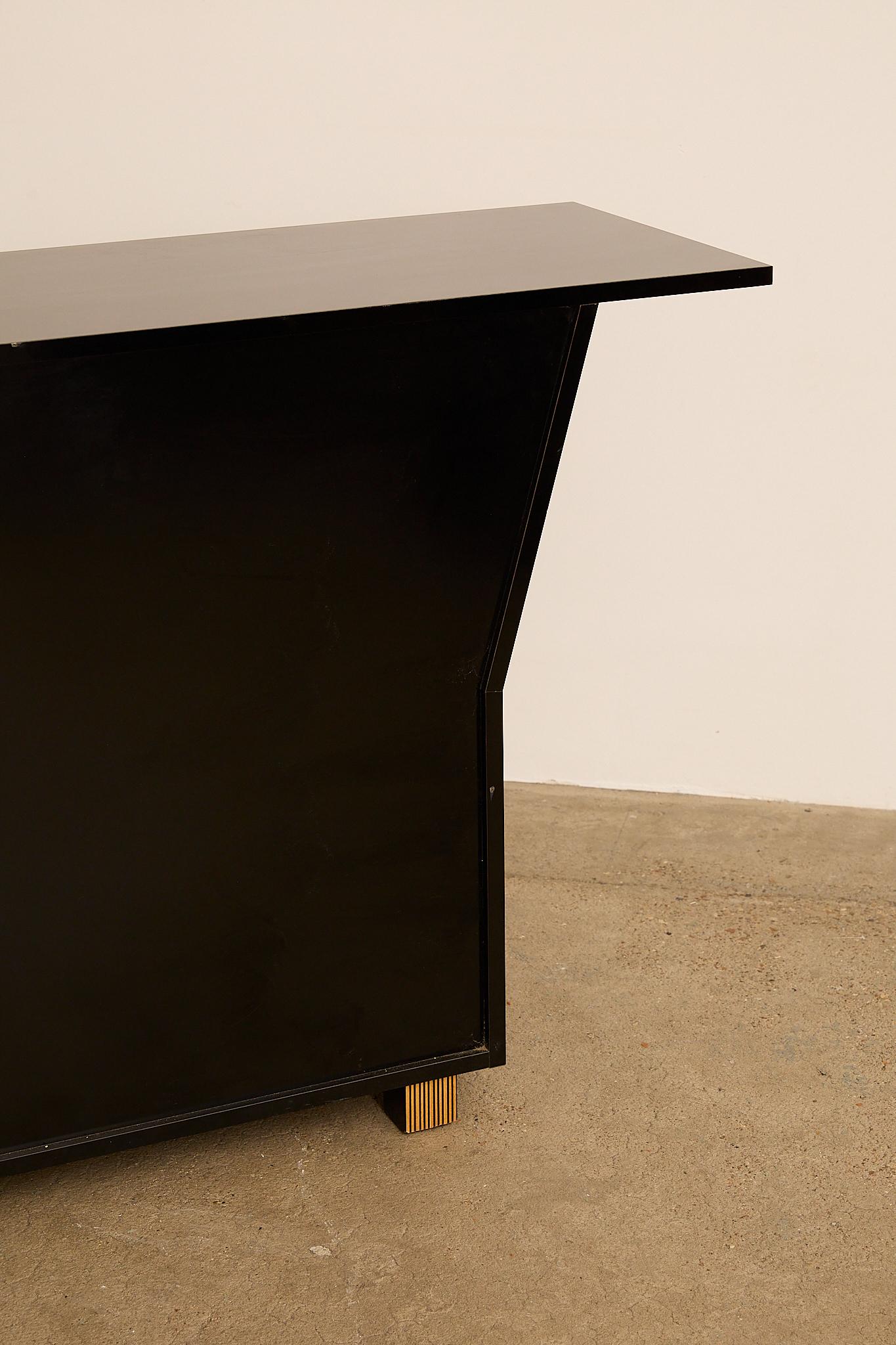 Elegant 1970s Italian sideboard with a bold, architectural silhouette in glossy black lacquer. Striped wood inlay edges add warmth and depth to its clean, geometric design, while the spacious storage and refined craftsmanship highlight the