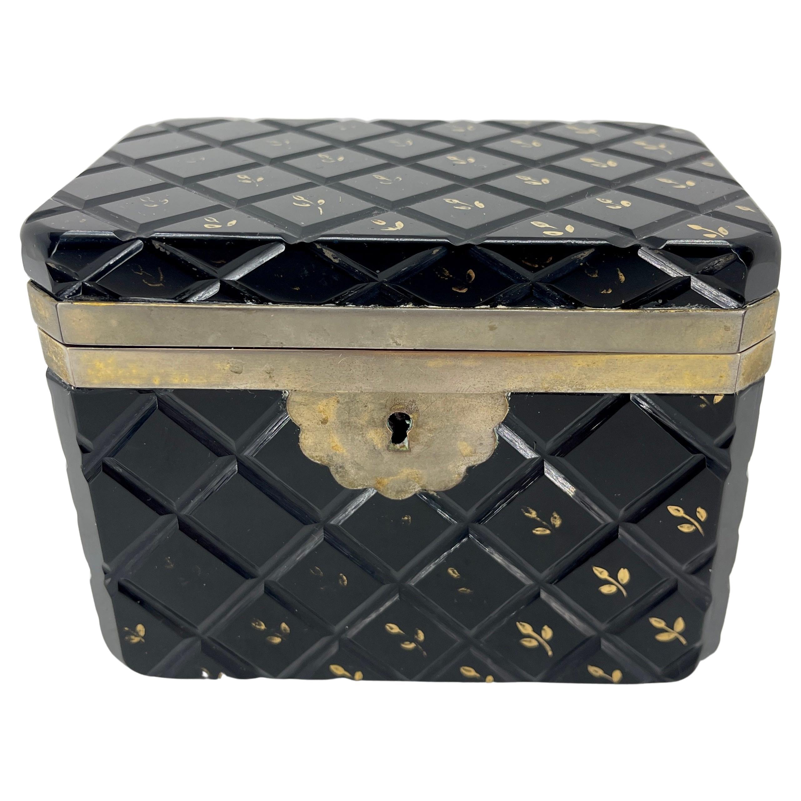 Black opaline glass jewelry box with cut diamond pattern and original brass hardware. The box is also decorated with gold leaves.