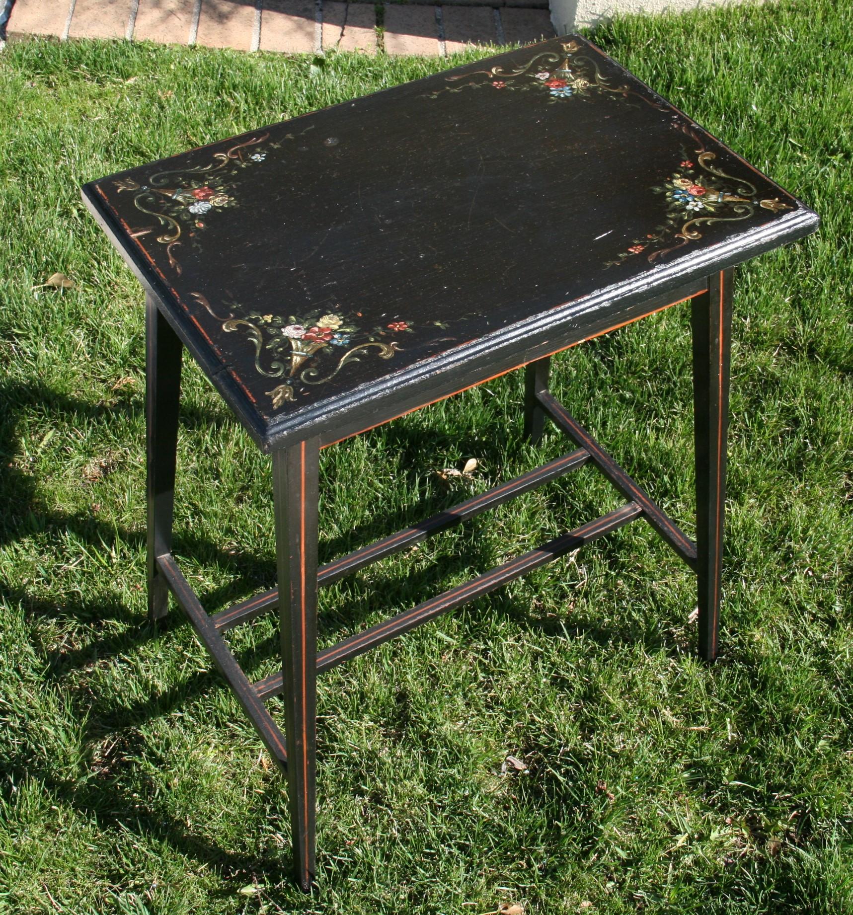 3-476 Italian black painted mahogany table with red pin strip details and hand painted floral details.
Lift top under table storage
 