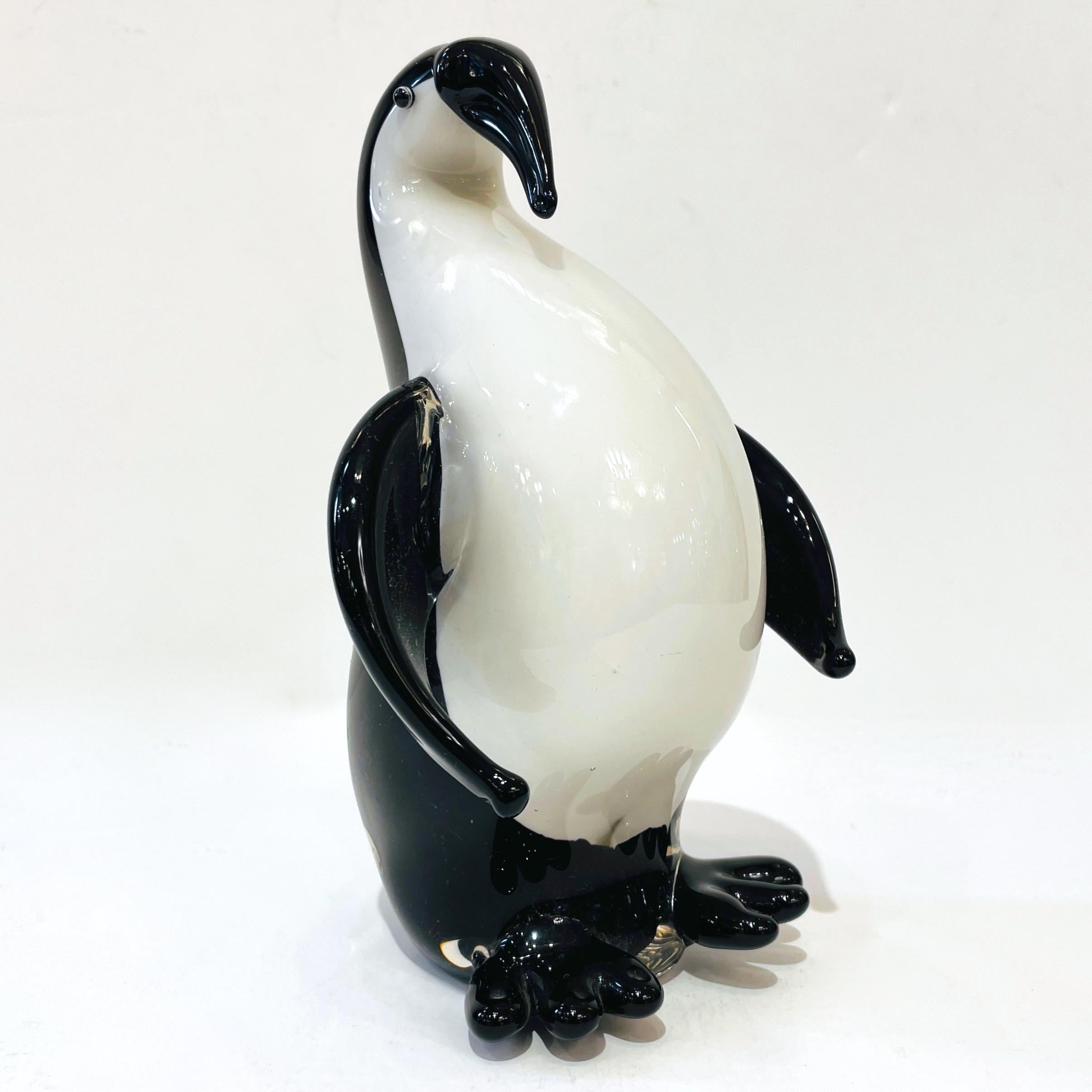 A modern Venetian penguin Art sculpture in blown Murano glass, a very cute realistic representation with an arched back to give movement to the animal, the central solid white core is deeply overlaid in black and crystal, with black feet and open