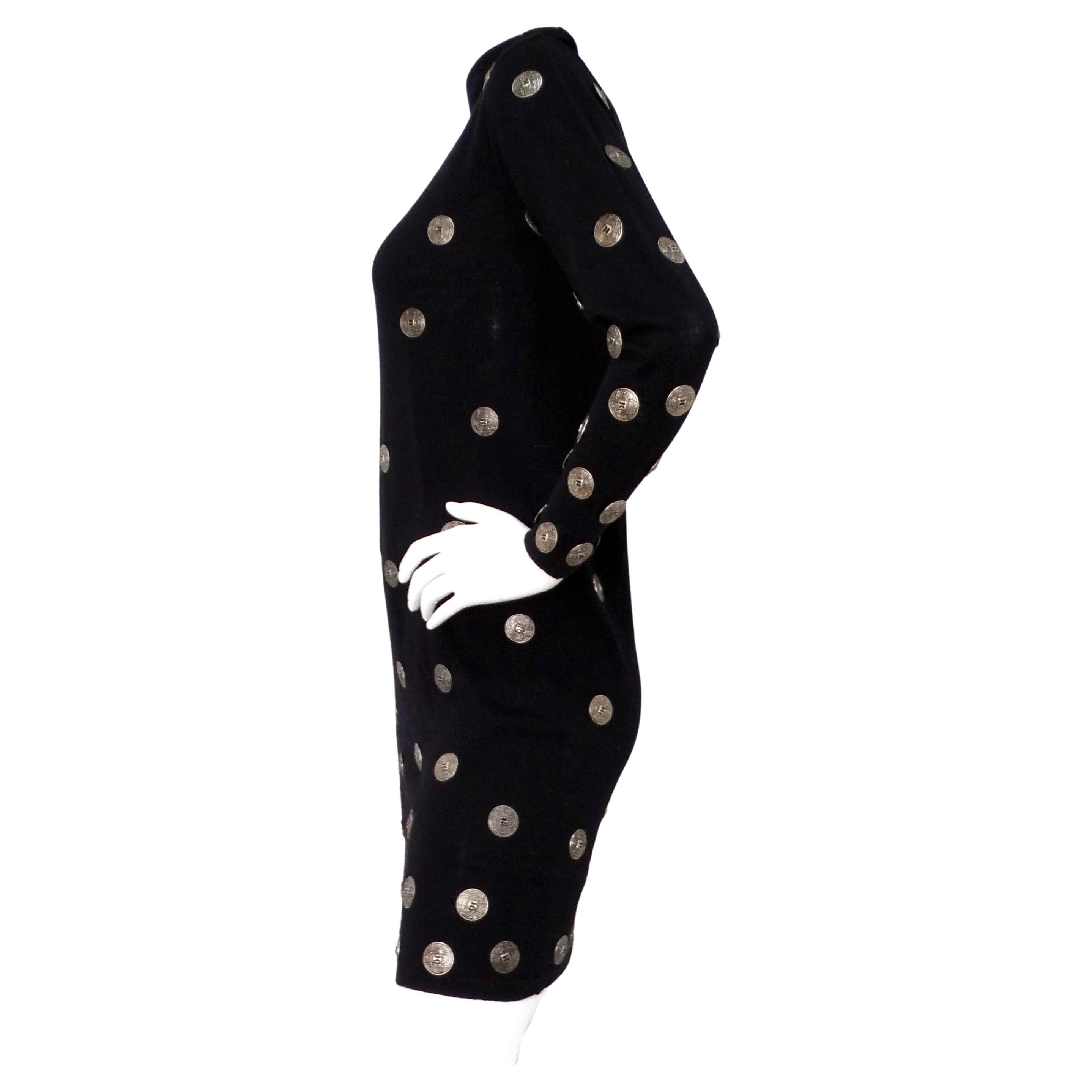 This Italian black wool long-sleeve dress with silver-tone medallion buttons, circa late 20th century, epitomizes timeless elegance and sophisticated craftsmanship. Crafted from rich Laine wool, the dress features a classic turtleneck silhouette