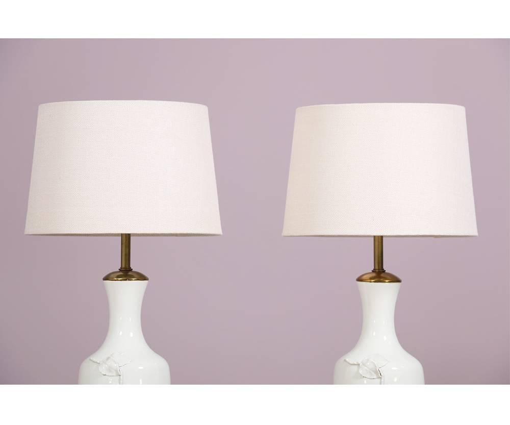 Beautiful Italian, 1950s pair of blanc de Chine table lamps with gilt wood and metal accents by the Marbro Lamp Company, Los Angeles. Each lamp has a single rose with stem applied to it’s body. Simple yet dramatic. Wired and in working condition.