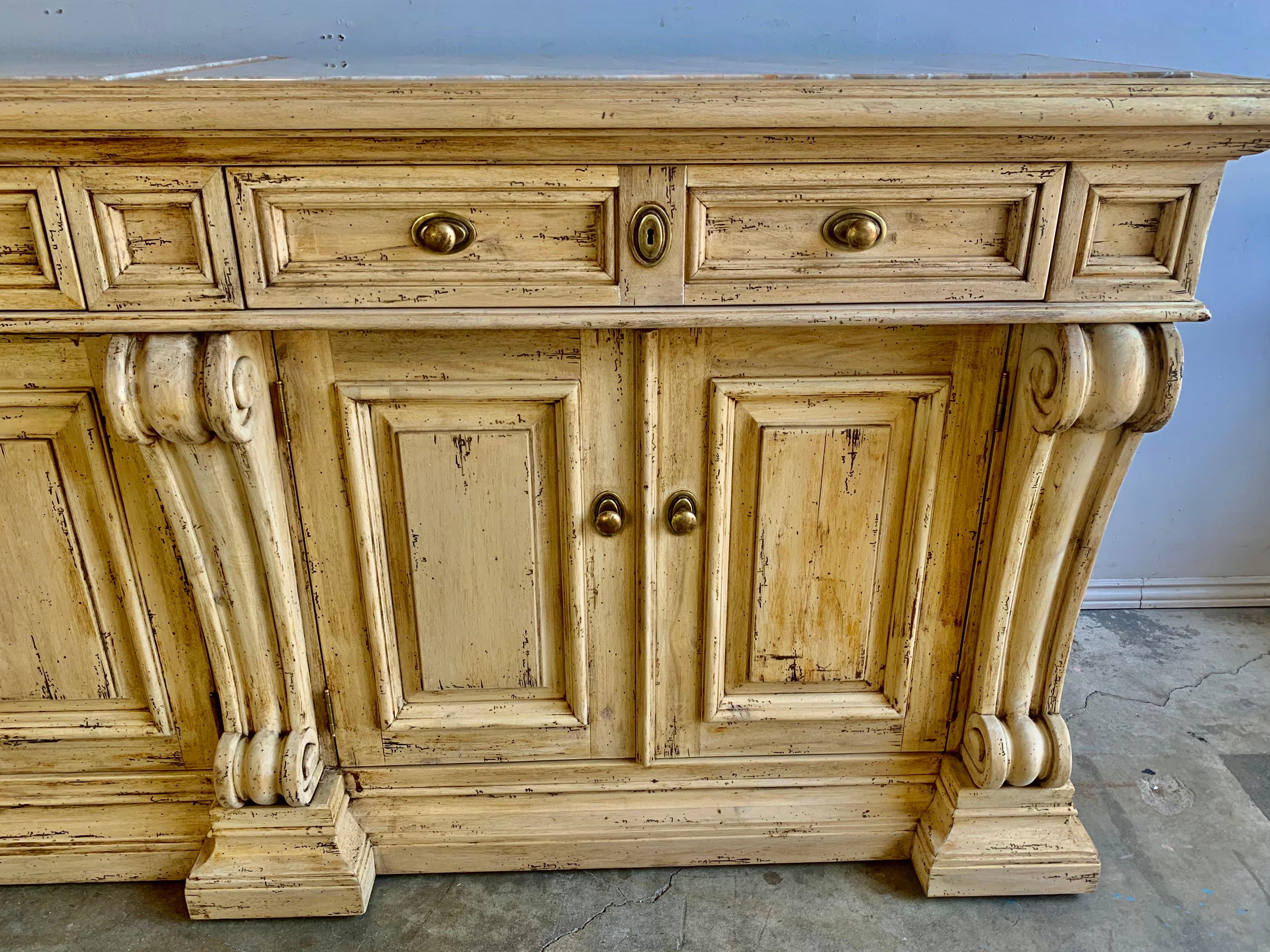 Italian bleached walnut carved wood sideboard. This Neoclassical style piece has plenty of storage with two drawers and cabinet underneath. Original brass hardware.