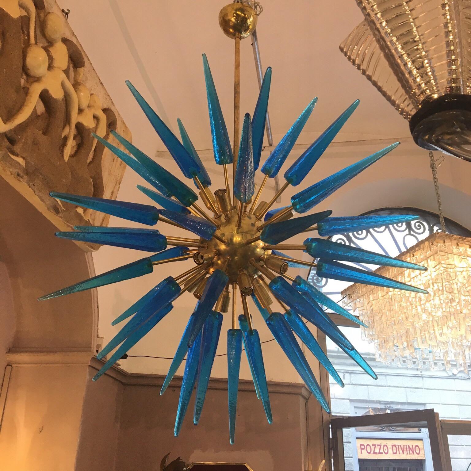 Italian blue Murano glass Sputnik chandelier, it consists of a center brass sphere to which numerous arms are attached each ending with an hand blown blue Murano glass tip with square section, 16 light bulbs.