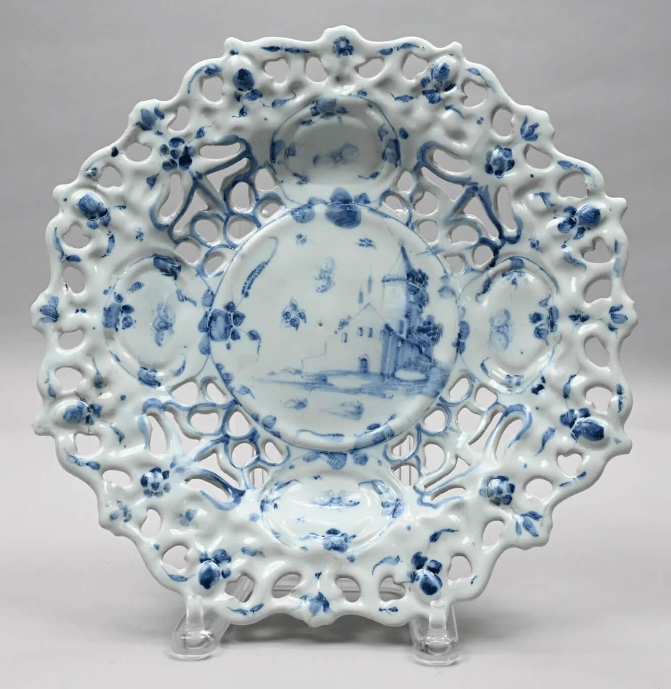 A circa 1690 Italian maiolica shallow tazza of Savona manufacture having elaborately molded and pierced rim with reserves decorated allover in hand-painted underglaze blue florals and butterflies with central architectural scene.  A wonderful