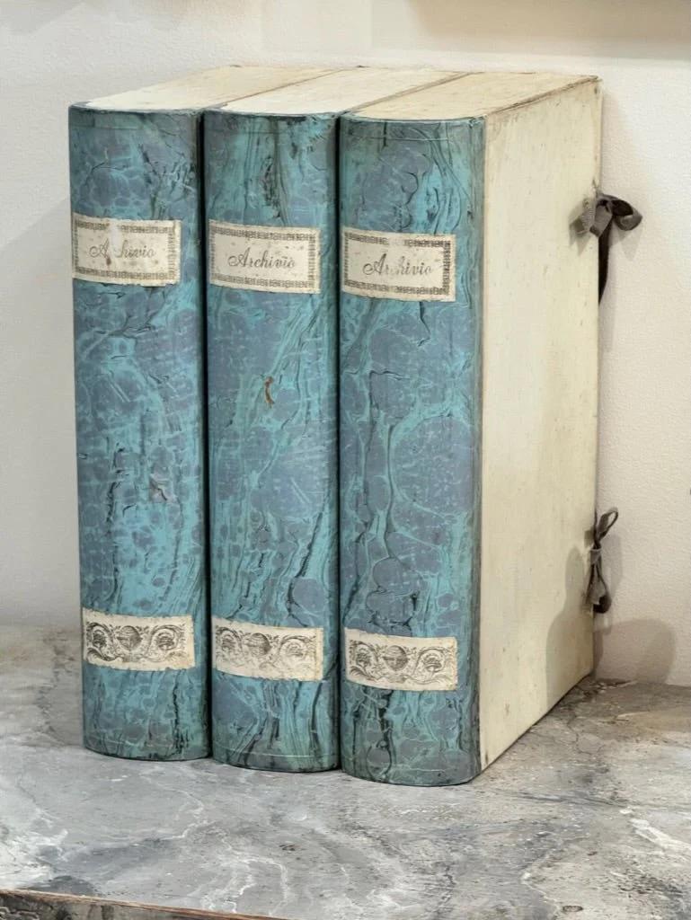 Italian blue paper book form file document boxes.  the spine in marbled turquoise paper the original ribbon to the center,  opening to reveal a roomy vacant inner storage compartment, and surviving from early twentieth century Italy.  Sold