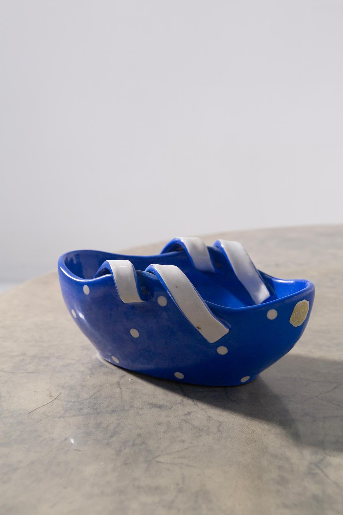 Exceptionnel vase signé Pucci Ceramiche, avec étiquette d'origine, datant des années 1950-60. Une pièce unique au fort impact visuel, réalisée en céramique émaillée bleue agrémentée de pois blancs. L'originalité du design tient à la fois à la forme