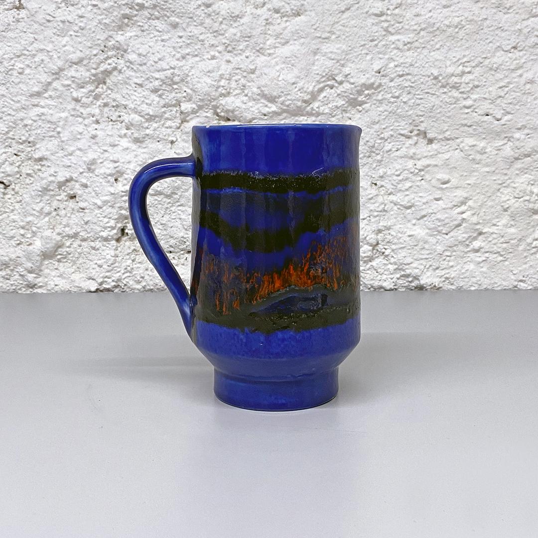 Italian Mid-Century Modern blue cylindrical ceramic jug with colored decoration, 1960s
Blue cylindrical ceramic jug, with colored abstract decoration.

Good condition, with small signs of wear.

Measurements: 14 x 16.5 H cm.