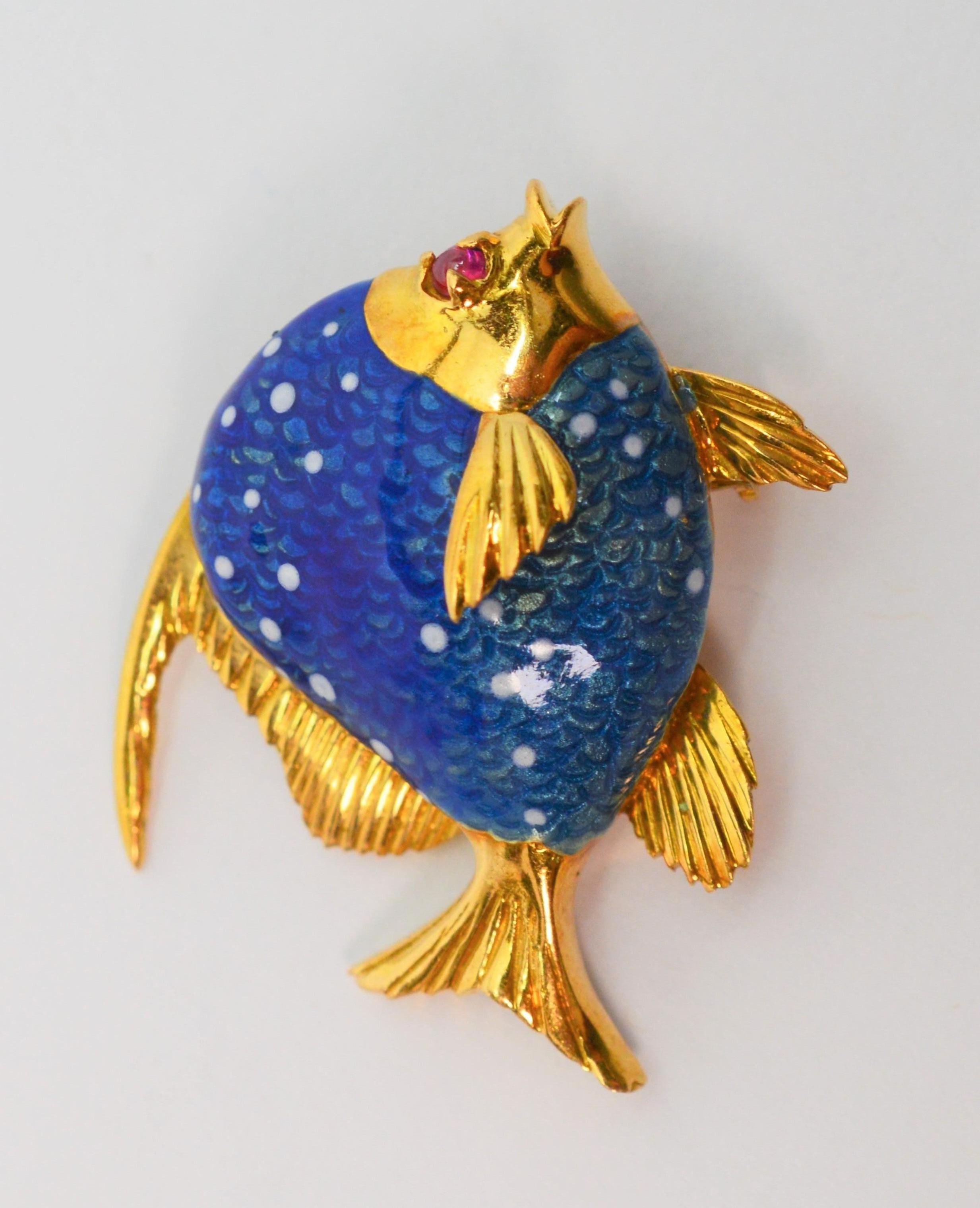 Animated in vibrant hand painted blue enamel this tiny aquatic creature with it ruby eye is a cheerful accent to any lapel or collar. 
Italian made of eighteen karat 18K yellow gold and measures 1-1/4 inches. Fitted with a rollover clasp and stamped