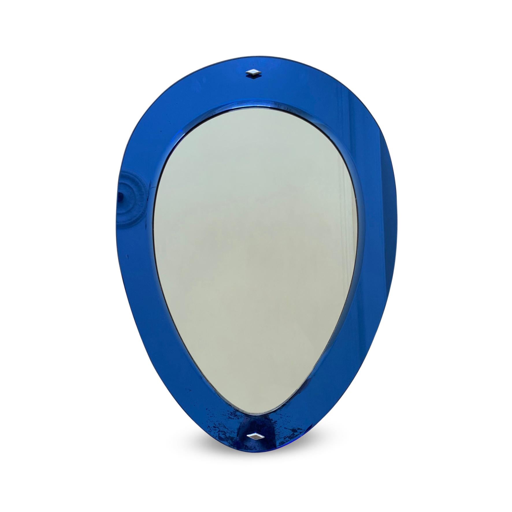 Italian Blue Glass Mirror, 1950s

A 1950s Italian oval mirror with a blue glass border.

Constructed from two pieces of mirrored glass, the frame and the mirror plate, fastened with two mirrored diamond-shaped screw heads.

Some foxing to both