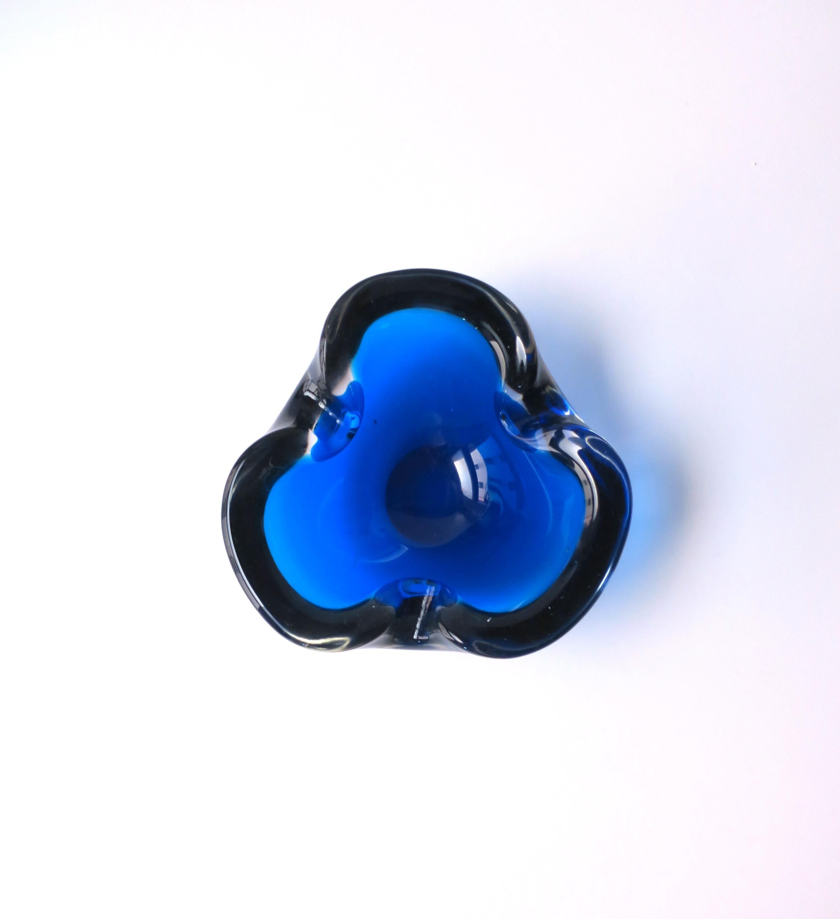 A substantial Italian Murano art glass bowl or ashtray in the style of artist Alfredo Barbini, Midcentury Modern period, circa mid-20th century, Italy. Piece is a rich cobalt or sapphire blue and transparent art glass. Great as a standalone piece