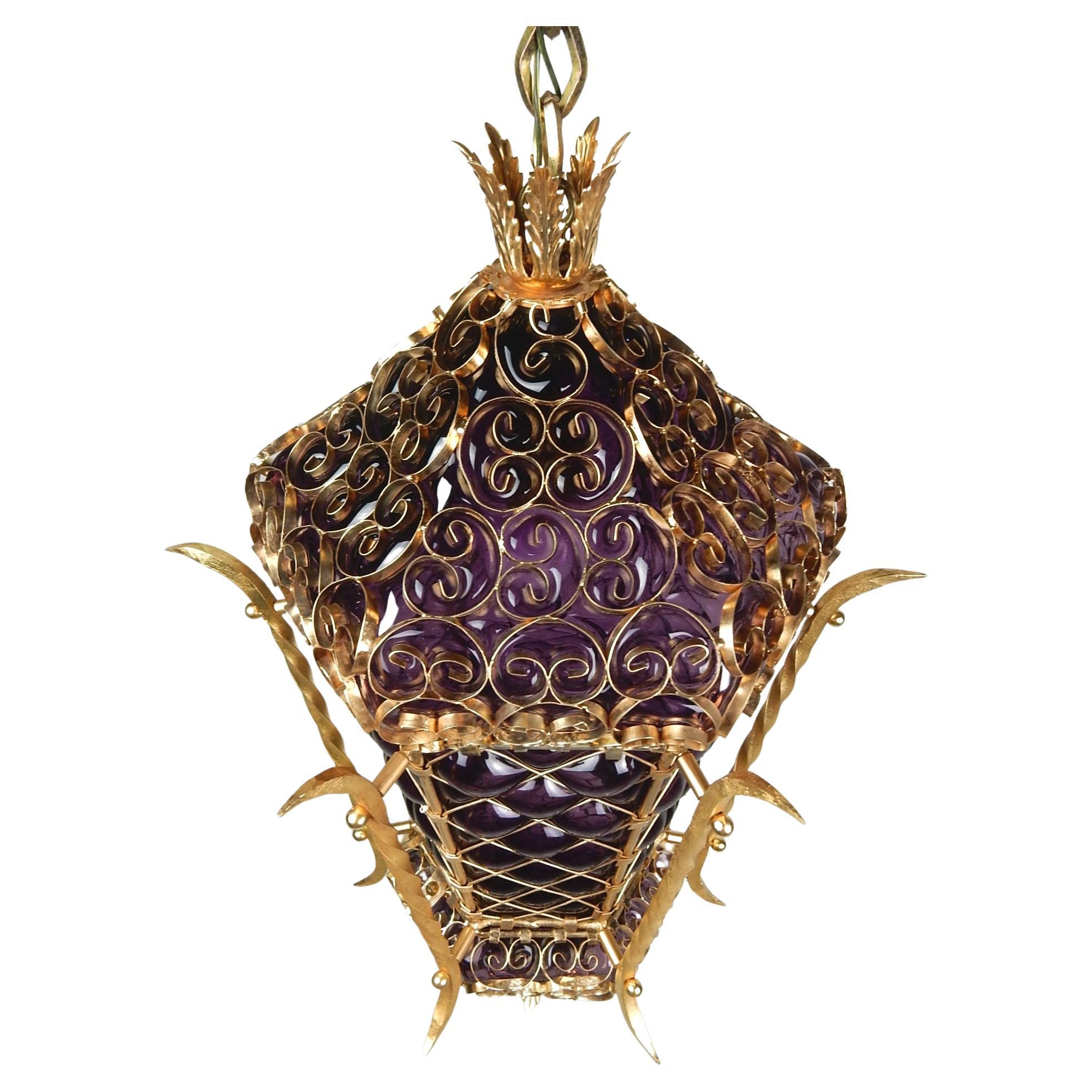 Splendida lampada a sospensione in vetro viola con gabbia di Boemia e metallo dorato, anni '60 circa.
Il ciondolo da 24 X 16 pollici è dotato di una sola lampadina standard.
Le fasce sono montate su una catena personalizzata di 15 piedi o possono