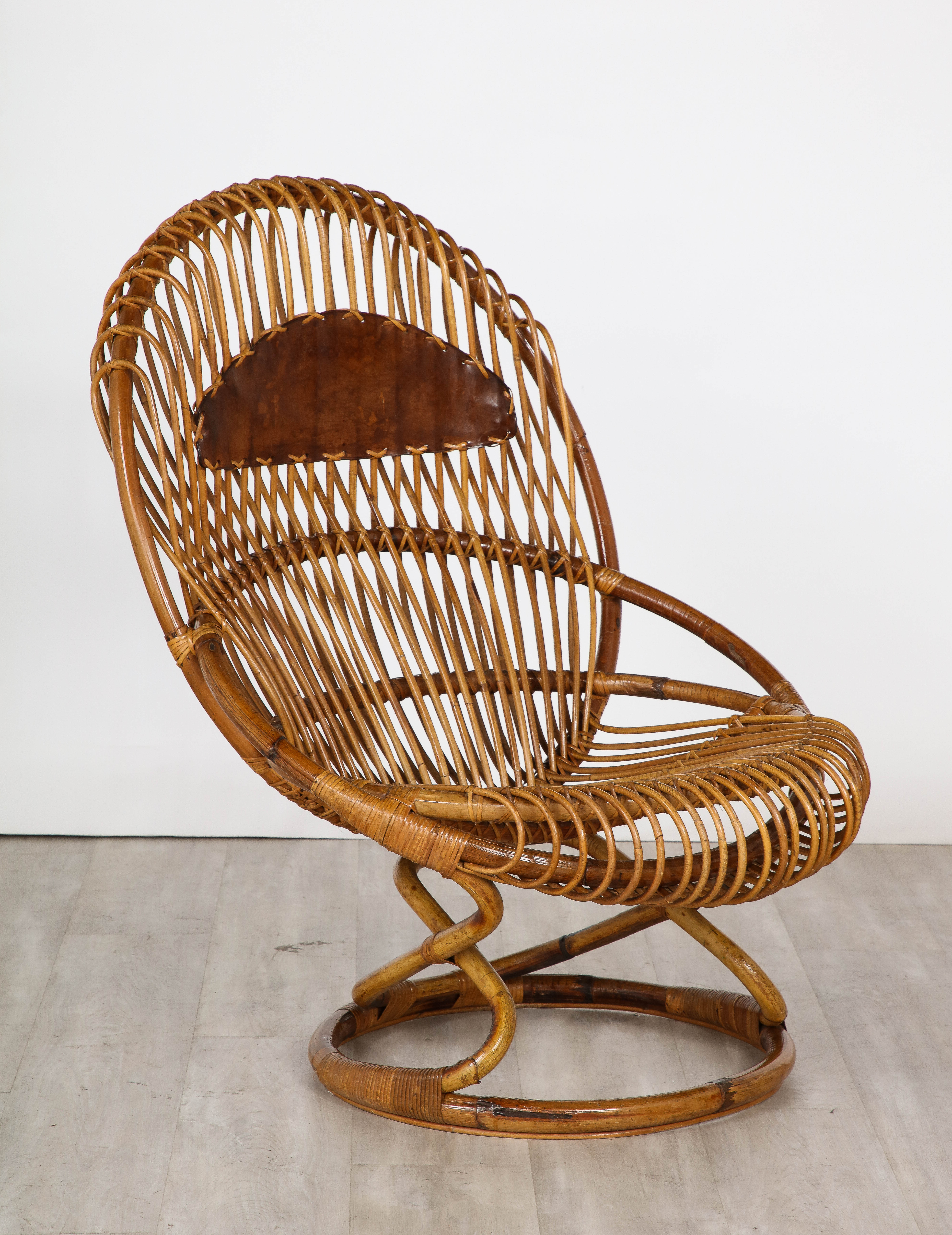 An oversized rattan and leather lounge chair designed by Tito Agnoli for Bonacina in the 1950's.  A highly sculptural design, highlighting the beauty of the natural wood, the color is warm and beautiful, the caramel brown leather on the backrest