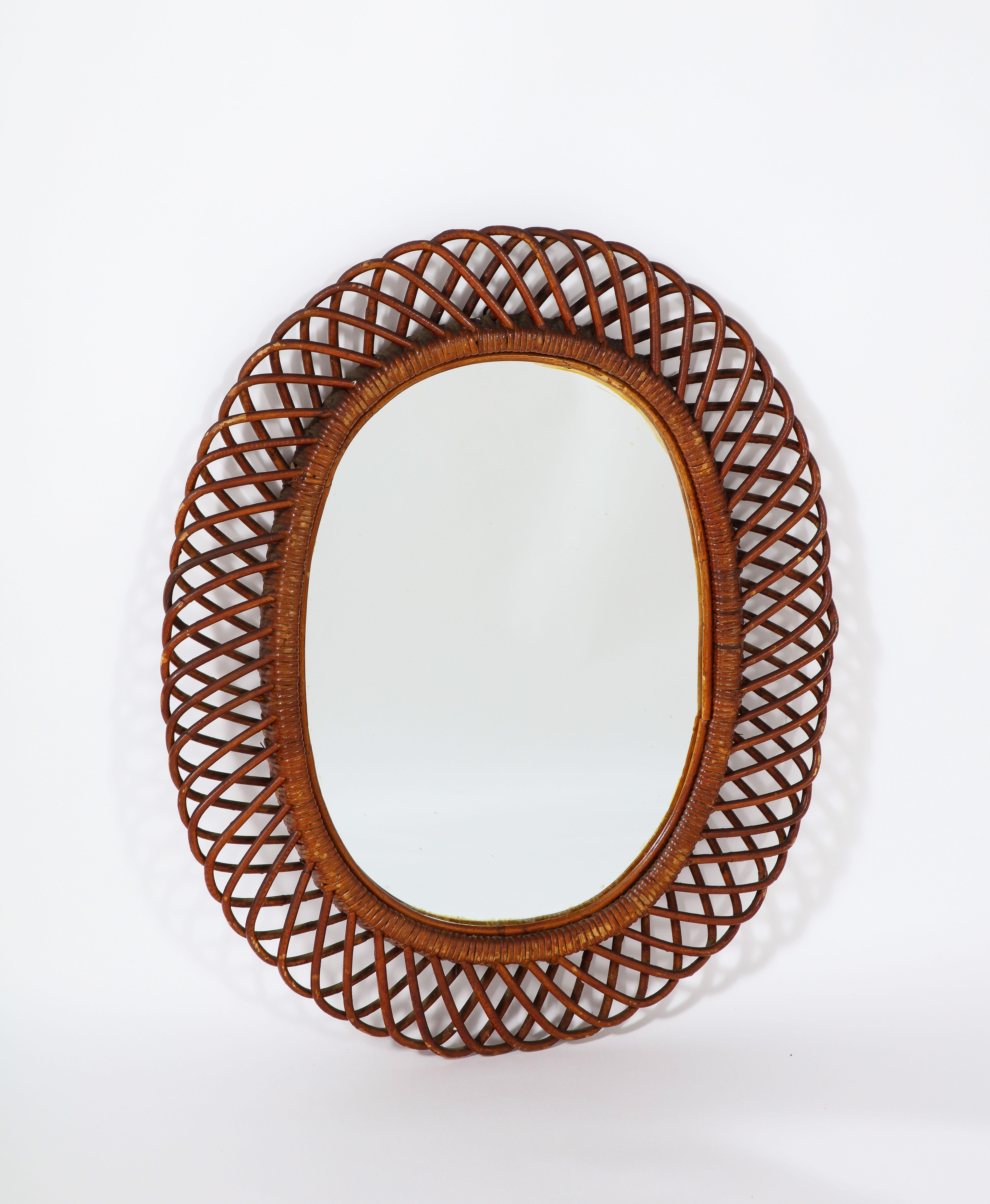 A classic Italian 1950's oval bamboo mirror by Bonacina; with original velvet backing. The bamboo has been stained, with a rich brown hue. 
Italy, circa 1950
Size: 29 1/2' high x 24 1/2
