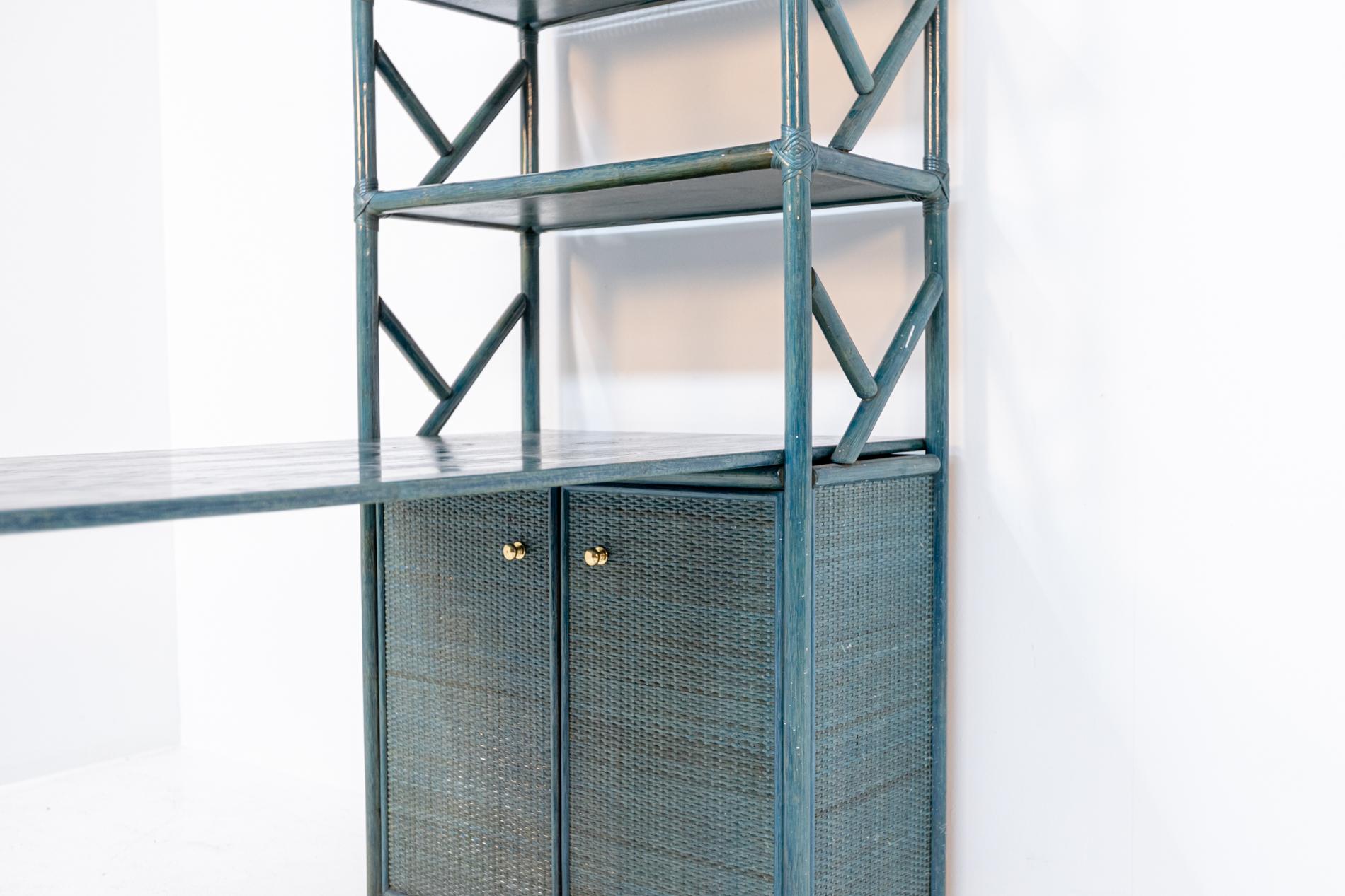 Beautiful bookcase with desk included in blue lacquered bamboo from the 1980s.
The bookcase has two shelves and at the bottom has two doors with gilt brass knobs and three more shelves inside.
The peculiarity of this furniture is that it also has