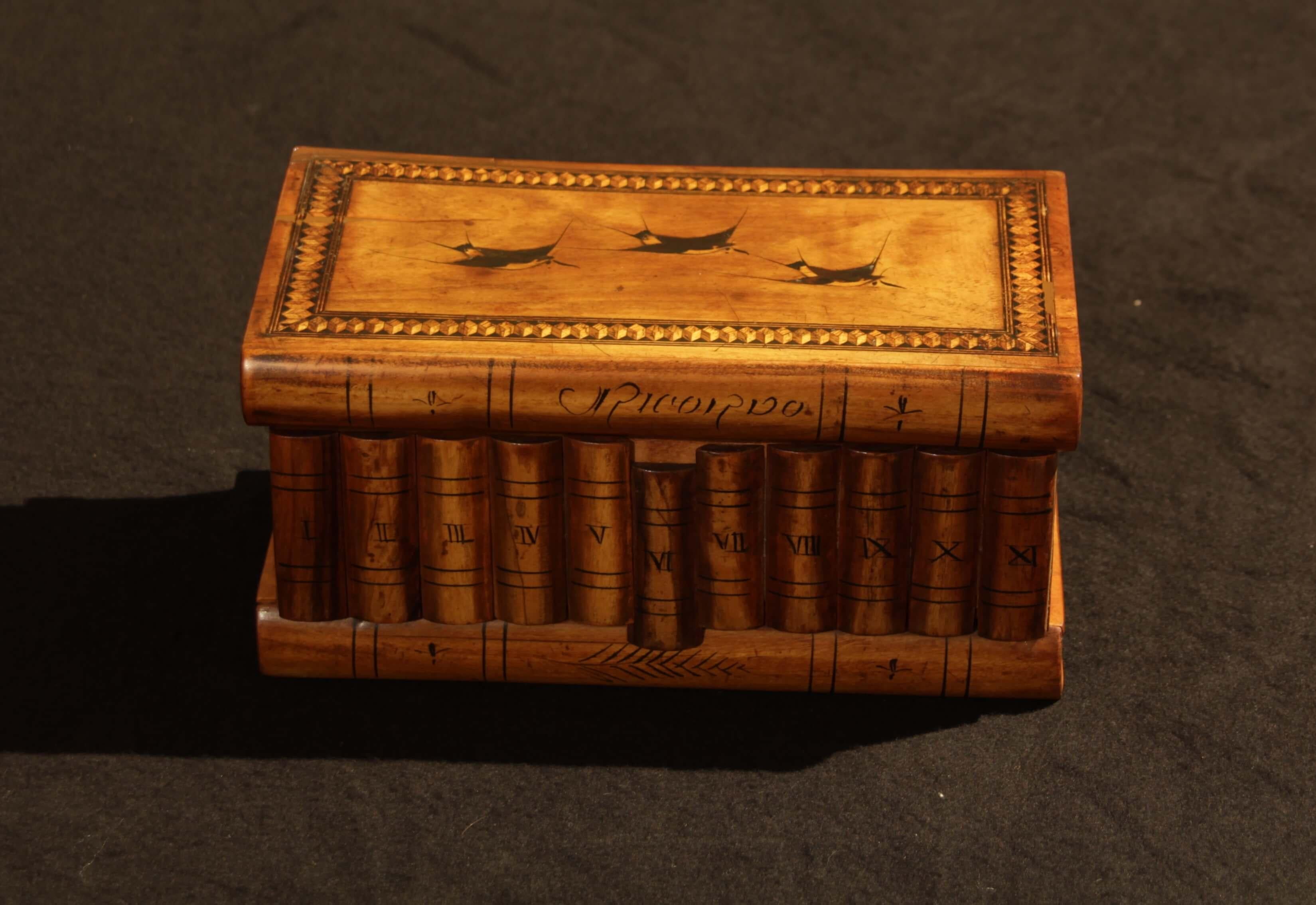 Lovely Italian jewelry casket box with Hidden compartment in the bottom.
Woods: Walnut with inlays of Ebony and Maple (French Polished).
The box is made to look like books from all sides.
There are three birds inlays and a wonderful dice frame