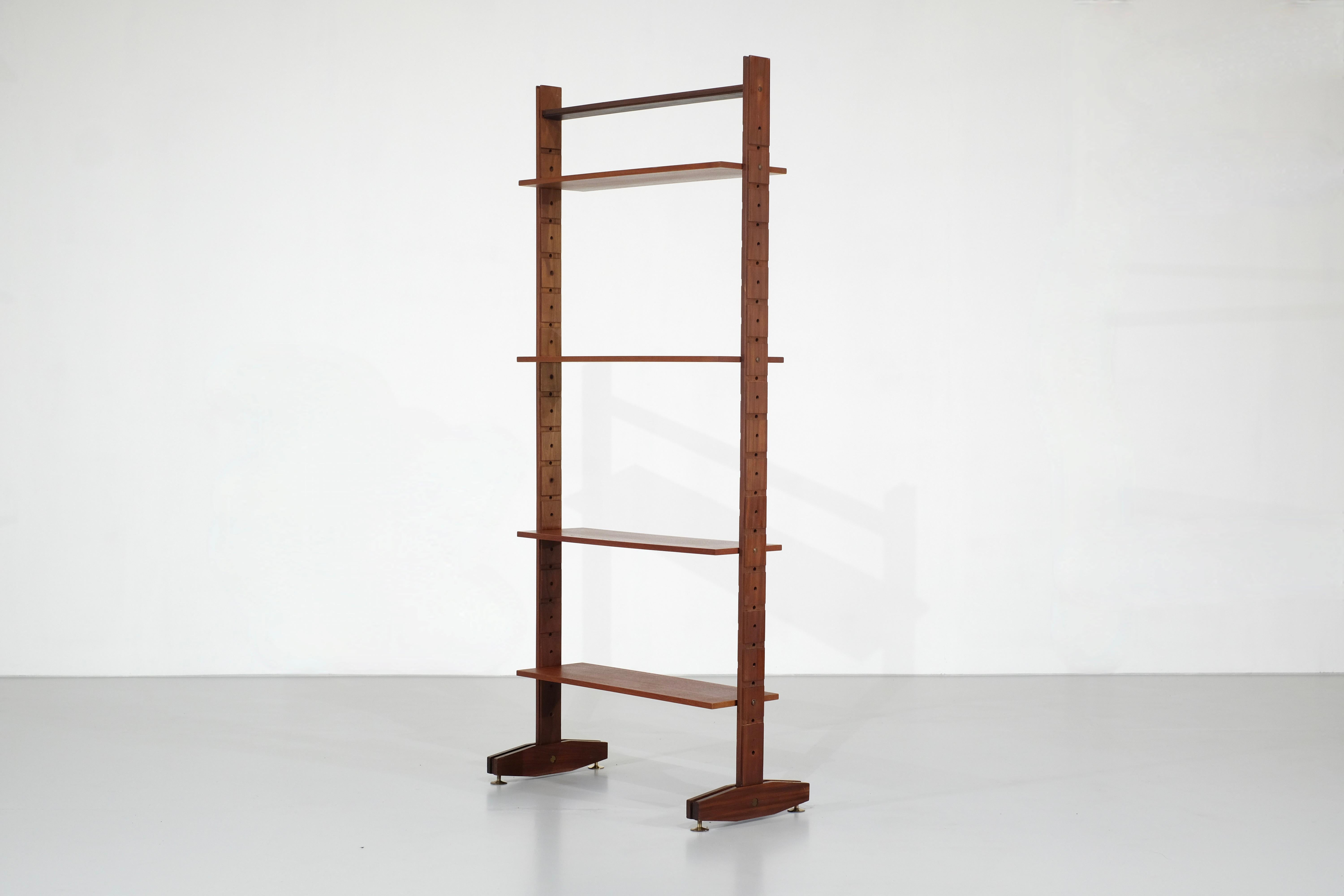 A superb little bookcase made from a single module.

The wood is teak, and all the hardware is brass.

It consists of four adjustable shelves, allowing you to position them as you wish.
The top bar provides stability to the module.

It would be