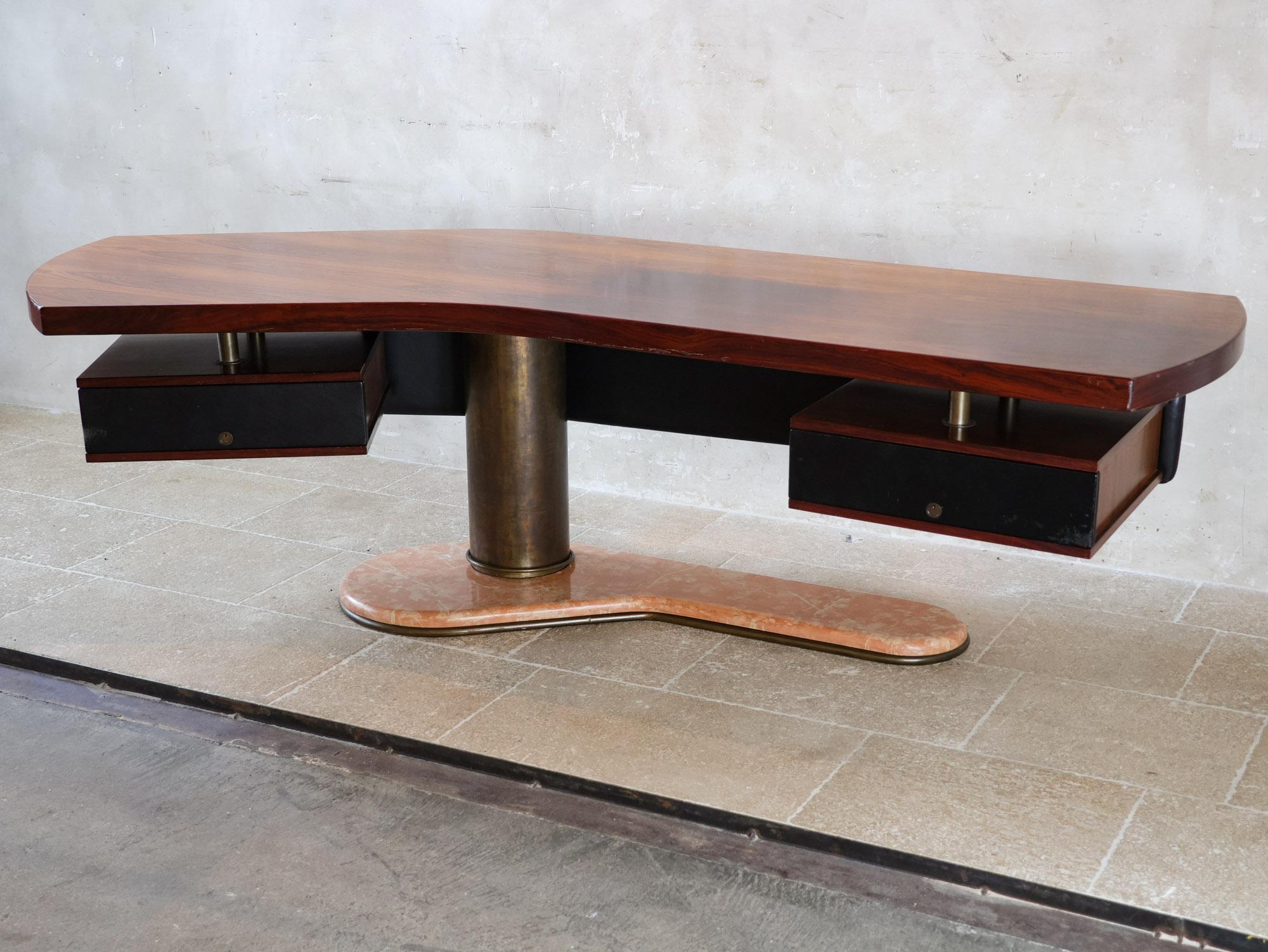 Boomerang desk by Renzo Schirolli, a striking piece from the 1960s. Renzo Schirolli's Booomerang desk symbolizes the bold elegance of Italian design from that time.

The desk has a unique boomerang-shaped top made of walnut, complemented by a panel