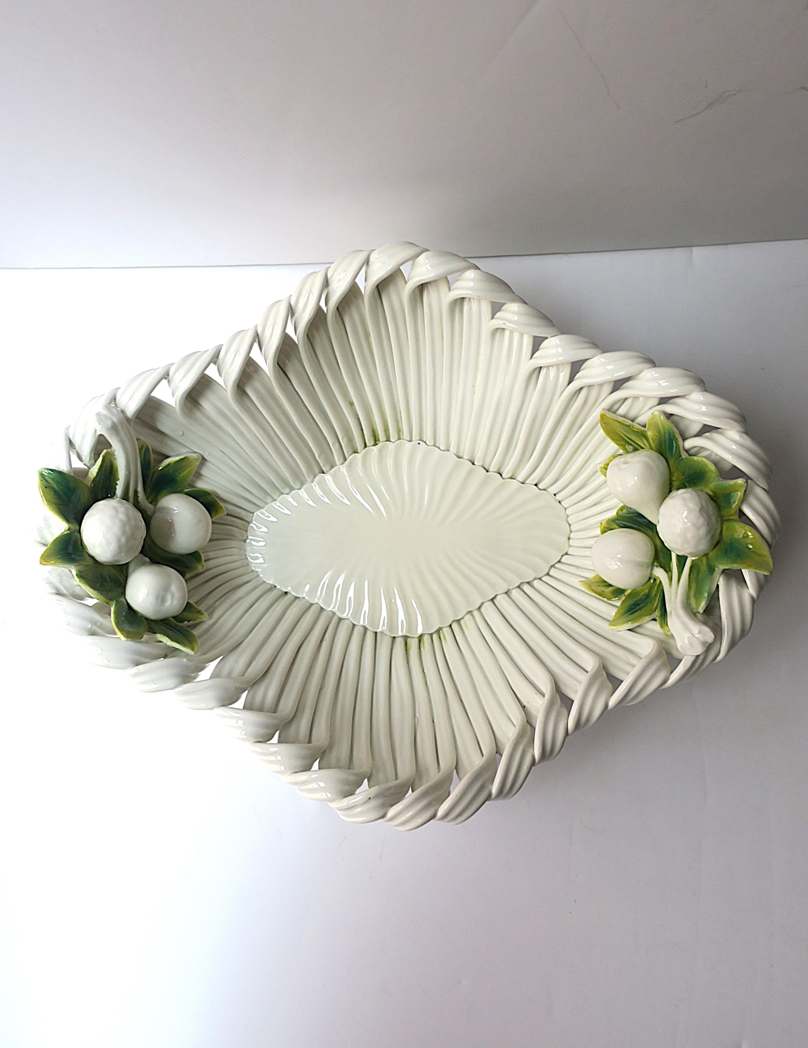 An Italian white ceramic bowl with fruit and leaf design in Trompe L'oeil style, circa mid-20th century, Italy. An oval bowl with ribbon-like design and fruit and leaves on each end (pears, cherry's, etc.) Great as a standalone piece or to hold