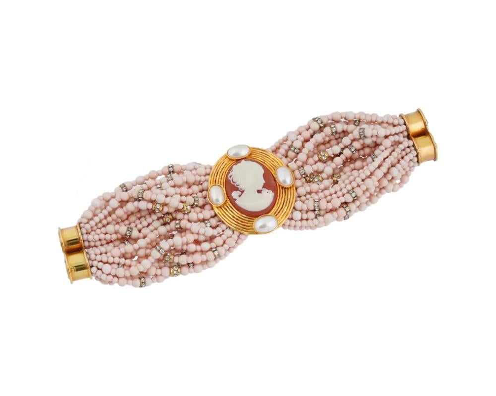 An Italian bracelet with pink and mother of pearl beads and a cameo by Valentino Garavani. The striking bracelet is made of multiple rows of pink and mother of pearl beads, gold plated fittings and an oval cameo with a female profile in the center.