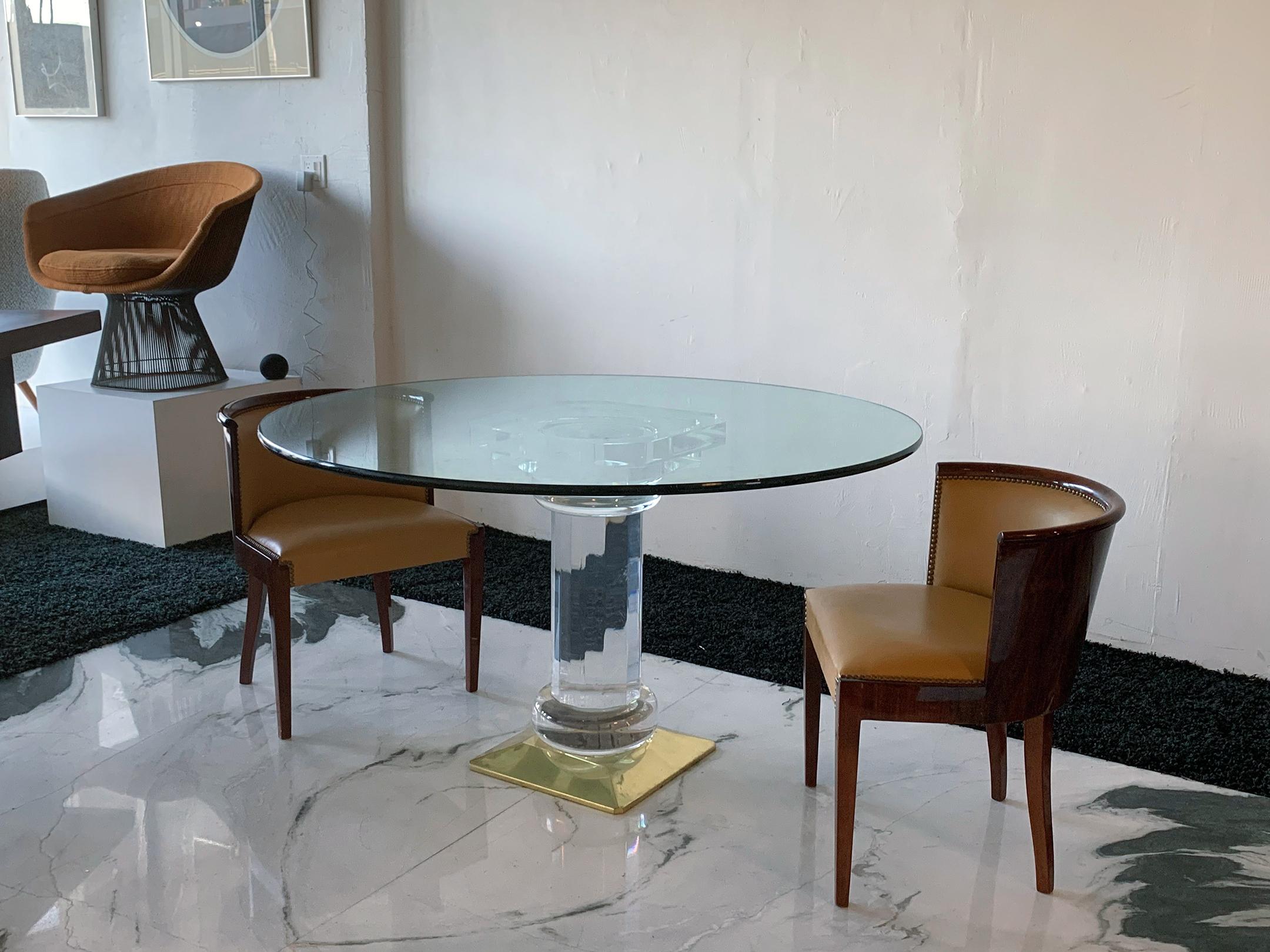 Available right now we have this stunning Italian acrylic and brass dining table, circa 1970s. The table base is comprised of solid acrylic with a square brass plated footing. This dining table would effortlessly blend with any type of Regency,